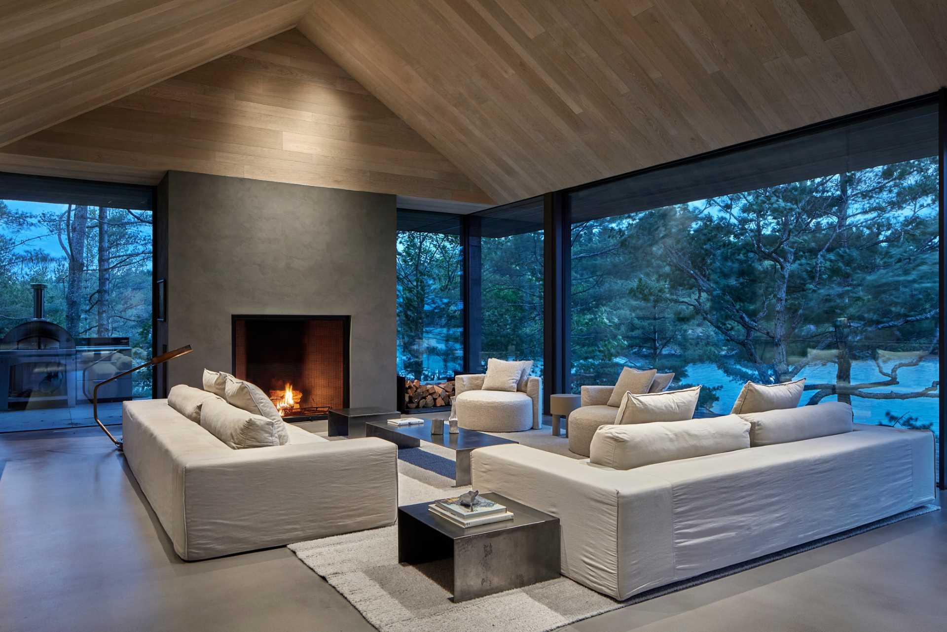 At the heart of this modern cottage is an open-concept living and dining area framed by a vaulted ceiling encased in hand-brushed European oak boards. 