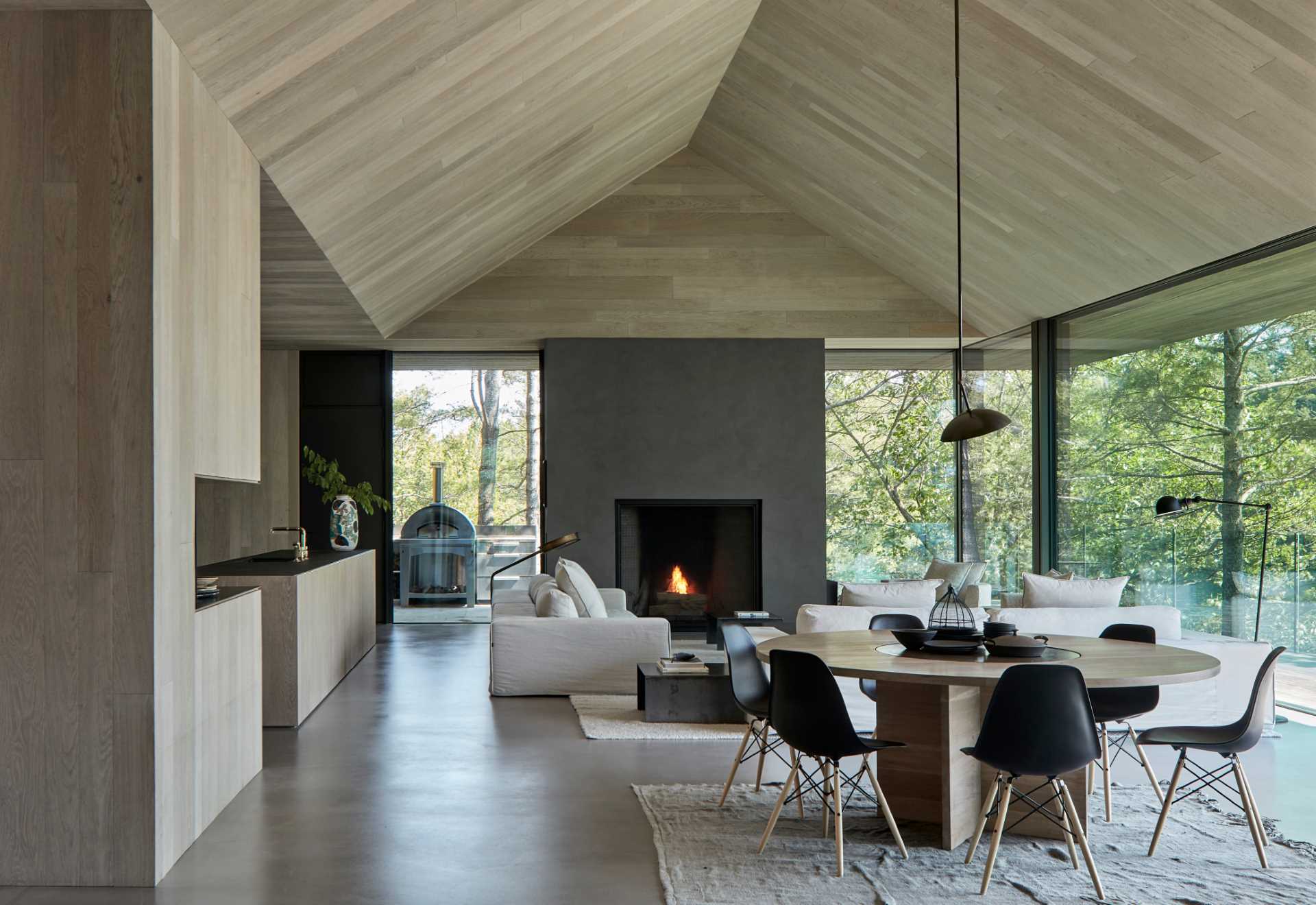 At the heart of this modern cottage is an open-concept living and dining area framed by a vaulted ceiling encased in hand-brushed European oak boards. 
