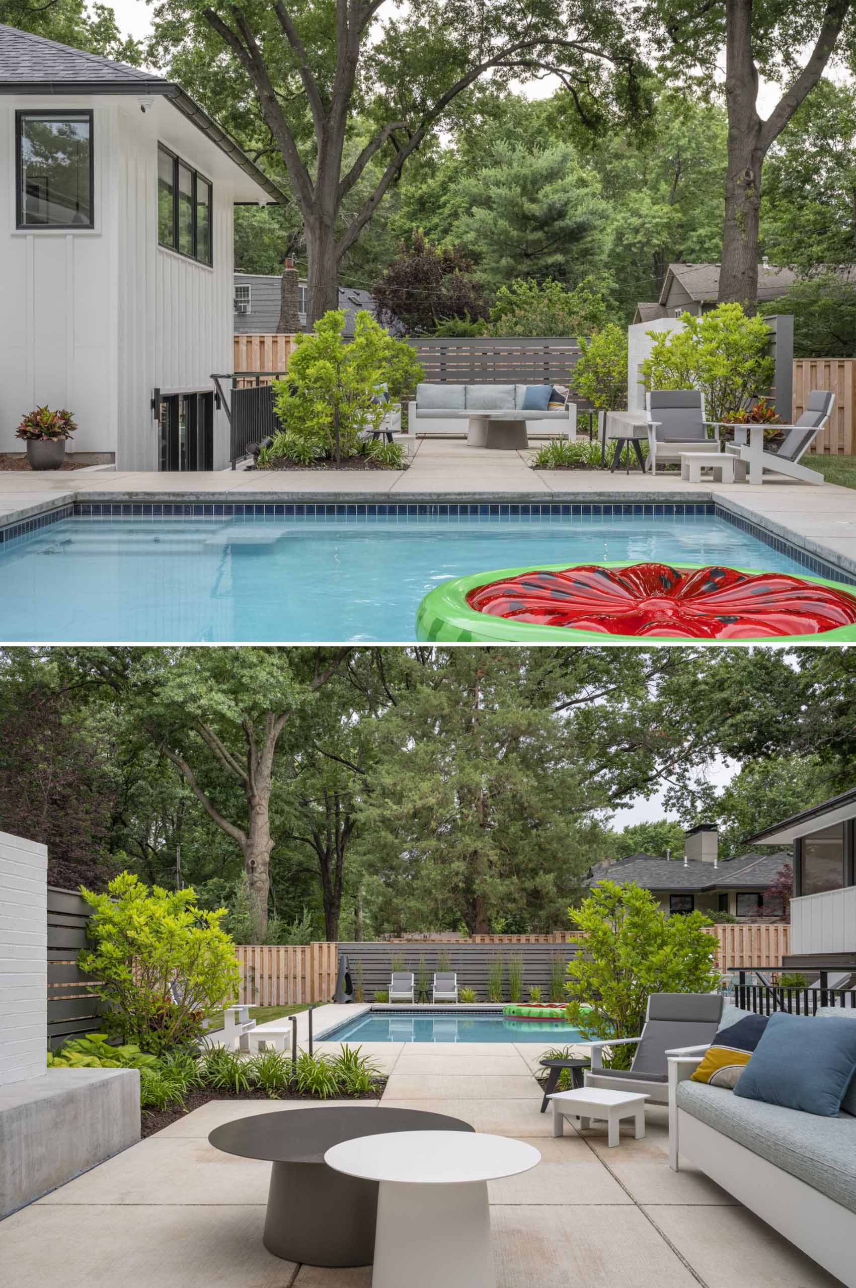 A landscaped backyard with a swimming pool and a patio furnished with plants, an outdoor lounge, and a fireplace.