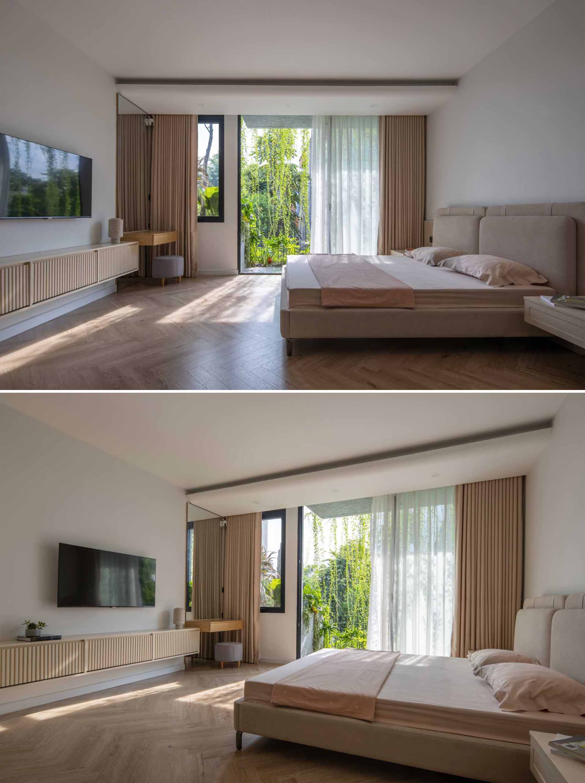 This primary bedroom has a neutral color palette, with floating bedside tables, closets, a dresser, and a vanity area. A sliding door connects the bedroom to a balcony with built-in planters.