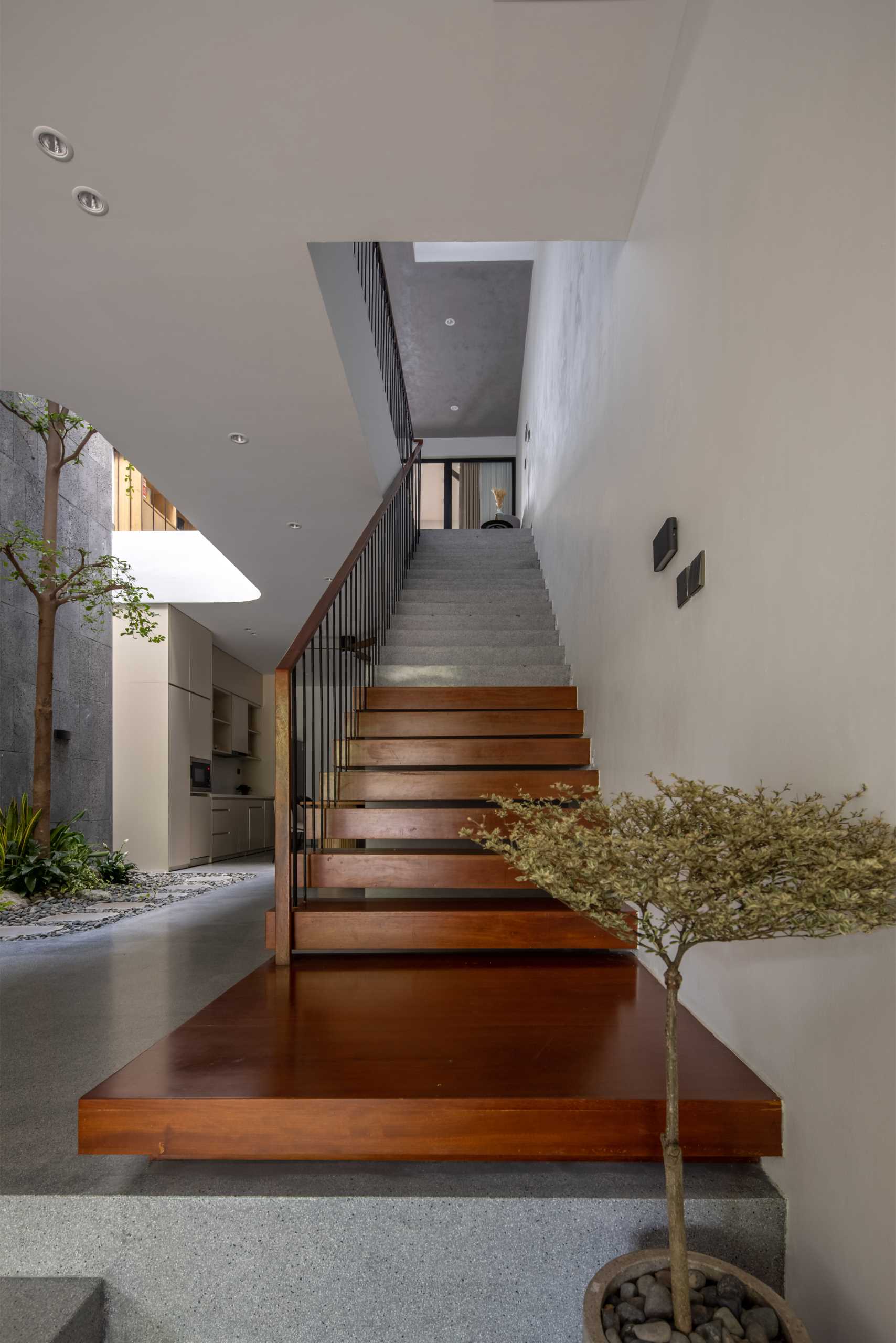 Wood and concrete stairs connect the various levels of the home, while interior bridges provide views of the garden and lead to the bedrooms.