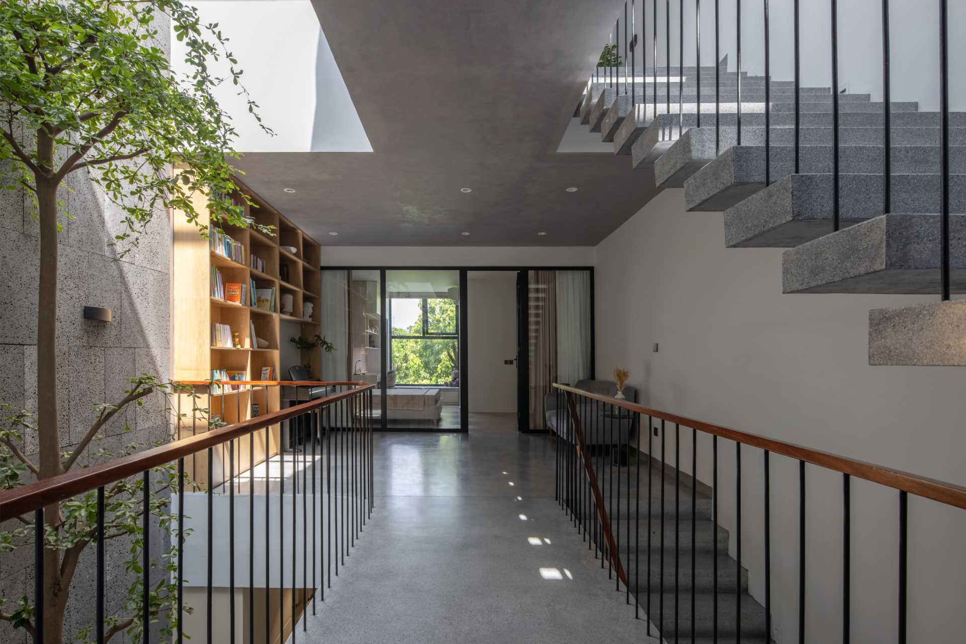Wood and concrete stairs connect the various levels of the home, while interior bridges provide views of the garden and lead to the bedrooms.