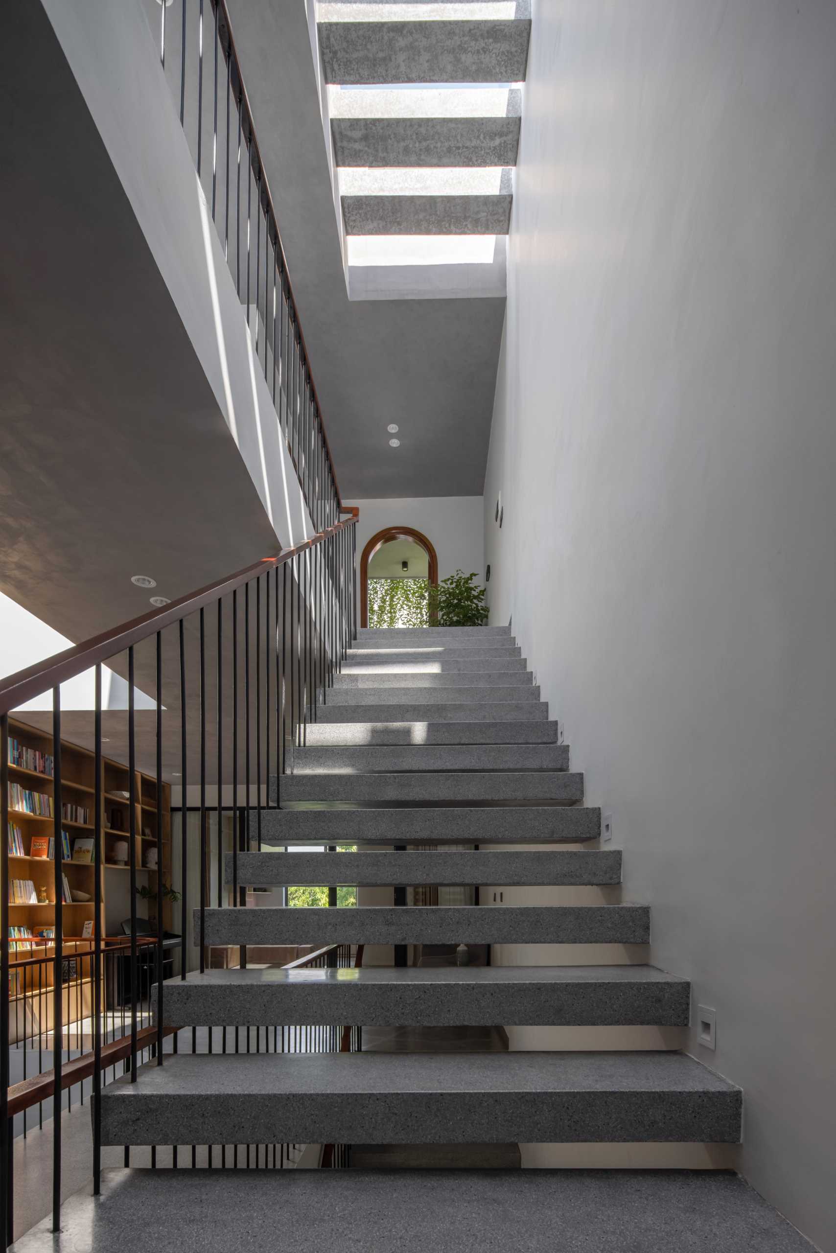 Wood and concrete stairs connect the various levels of the ،me, while interior bridges provide views of the garden and lead to the bedrooms.