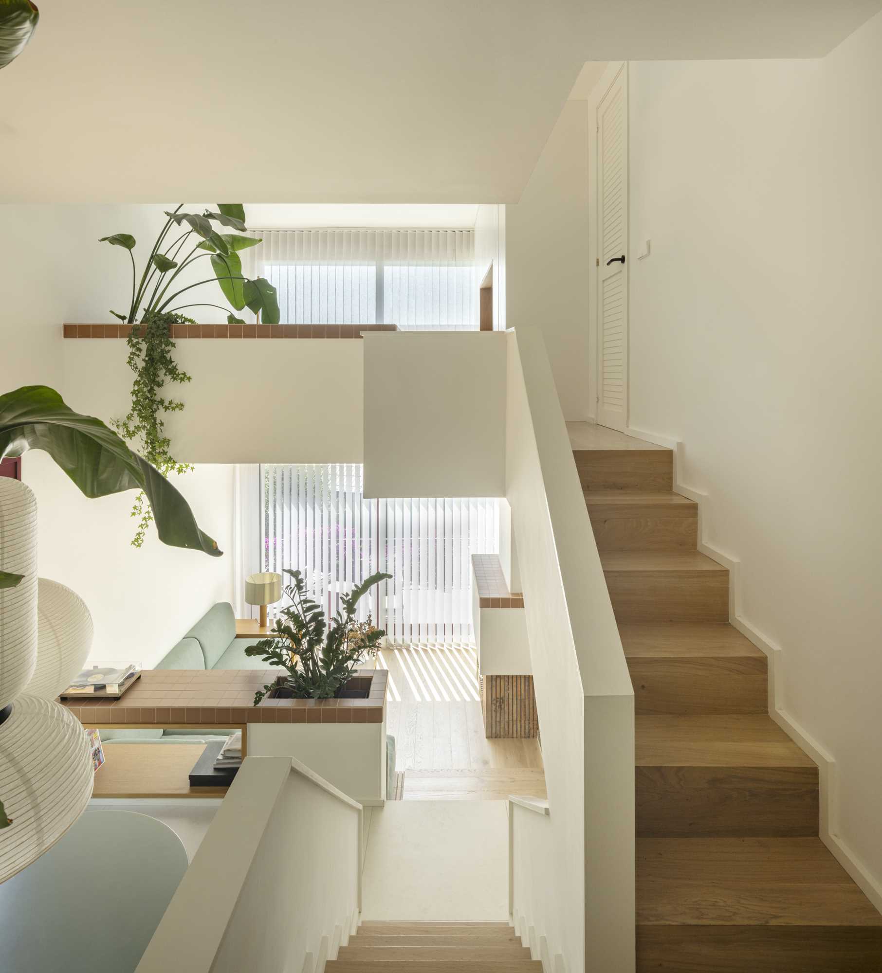 From this view on the entry level of a modern home, you can see the upper floor that includes a home office and the primary suite.