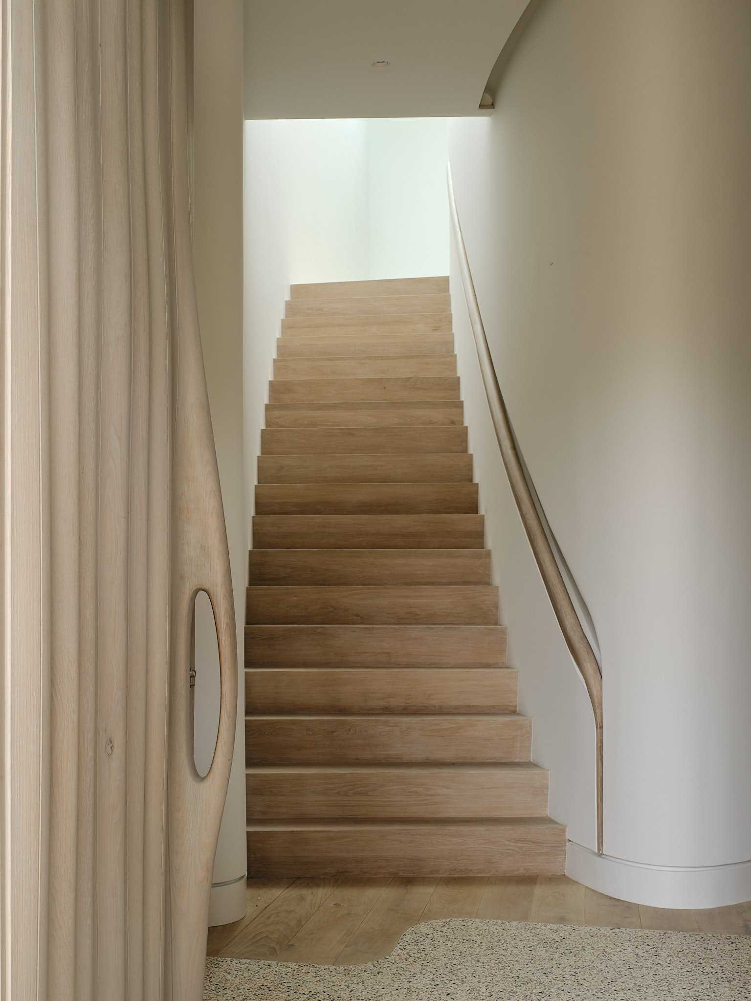 A unique design detail of the interior can be seen on the stairs, with the built-in custom-milled handrail that's recessed into the wall and includes hidden lighting.