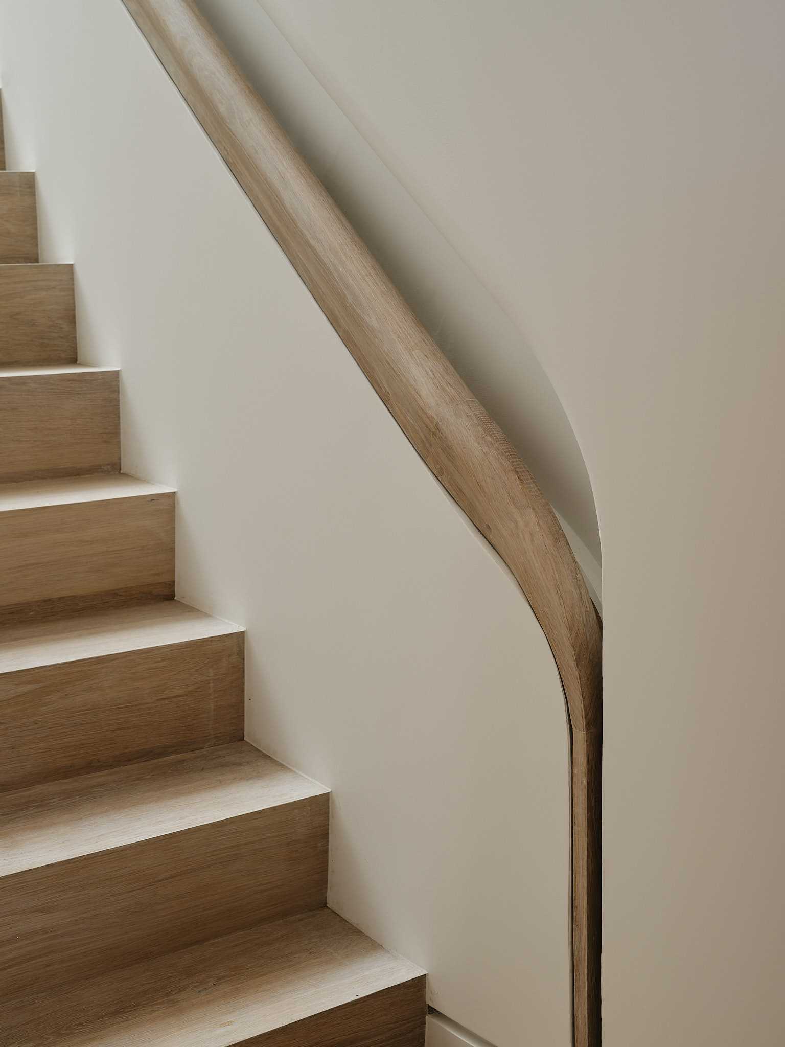 A unique design detail of the interior can be seen on the stairs, with the built-in custom-milled handrail that's recessed into the wall and includes hidden lighting.