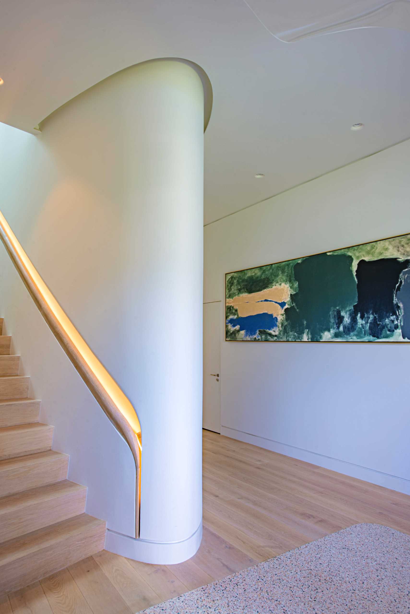 A unique design detail of the interior can be seen on the stairs, with the built-in custom-milled handrail that's recessed into the wall and includes hidden lighting.