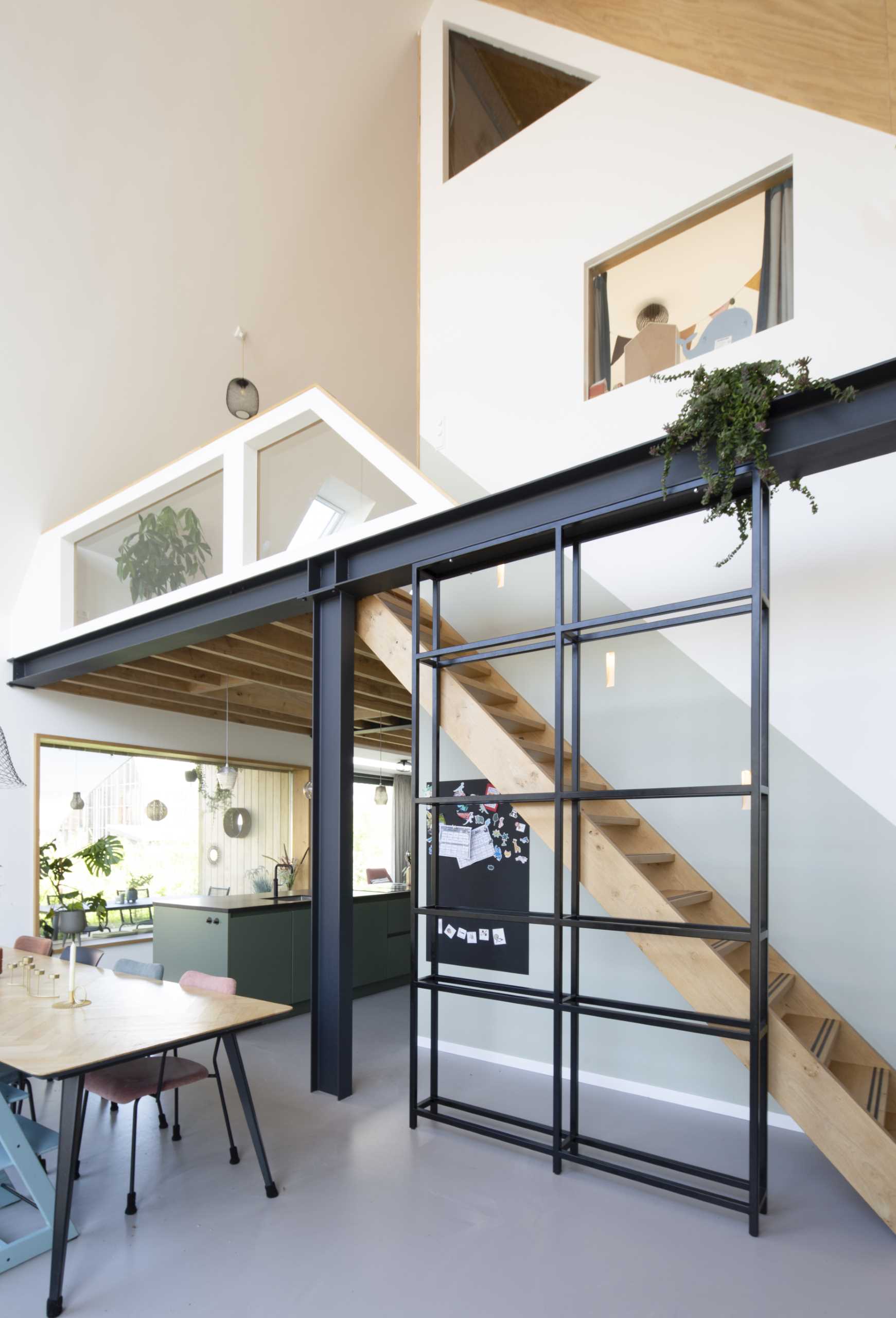 An open wooden staircase is supported by a steel rail, which also serves as a handrail, but can easily be converted into a bookcase due to its box shape.