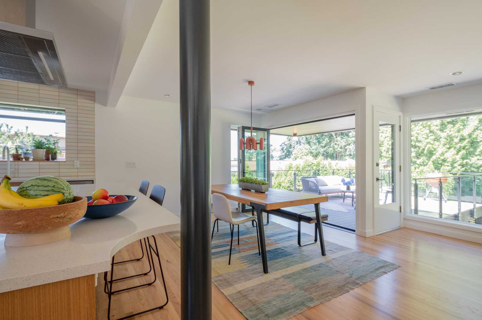 The updated dining area has been furnished with a wood table, while accordion doors connect to the doors.