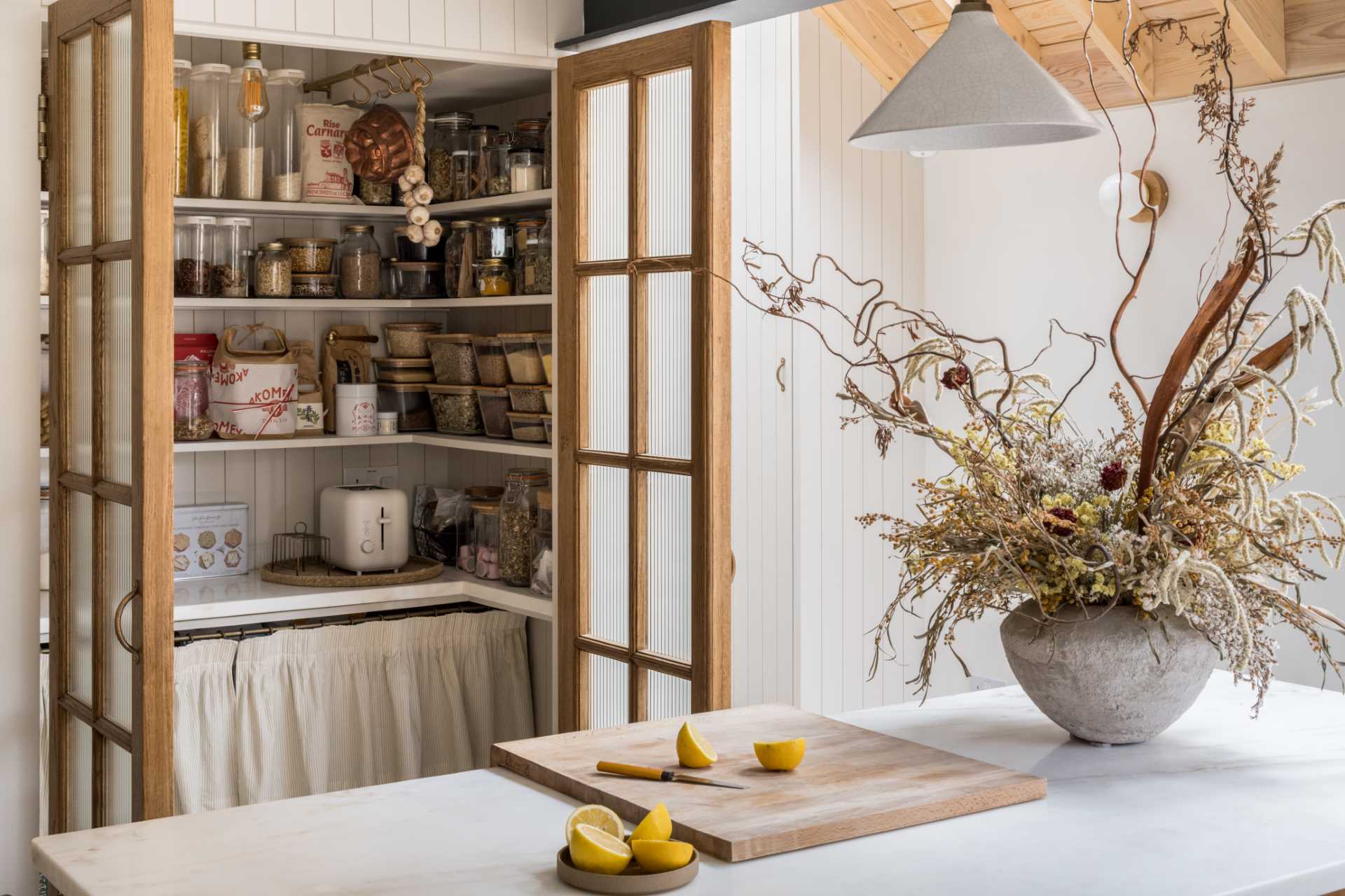 The pantry is considered the hub of the kitchen, with deep walnut framed doors hiding the shelving and storage when not in use.