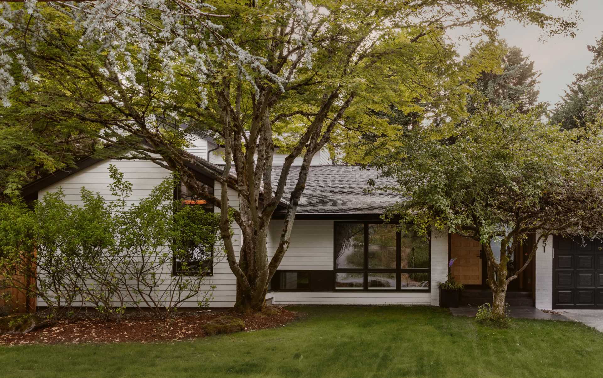 The new facade includes new siding, landscaping, and an enlarged entryway significantly enhancing the home's street appeal. 