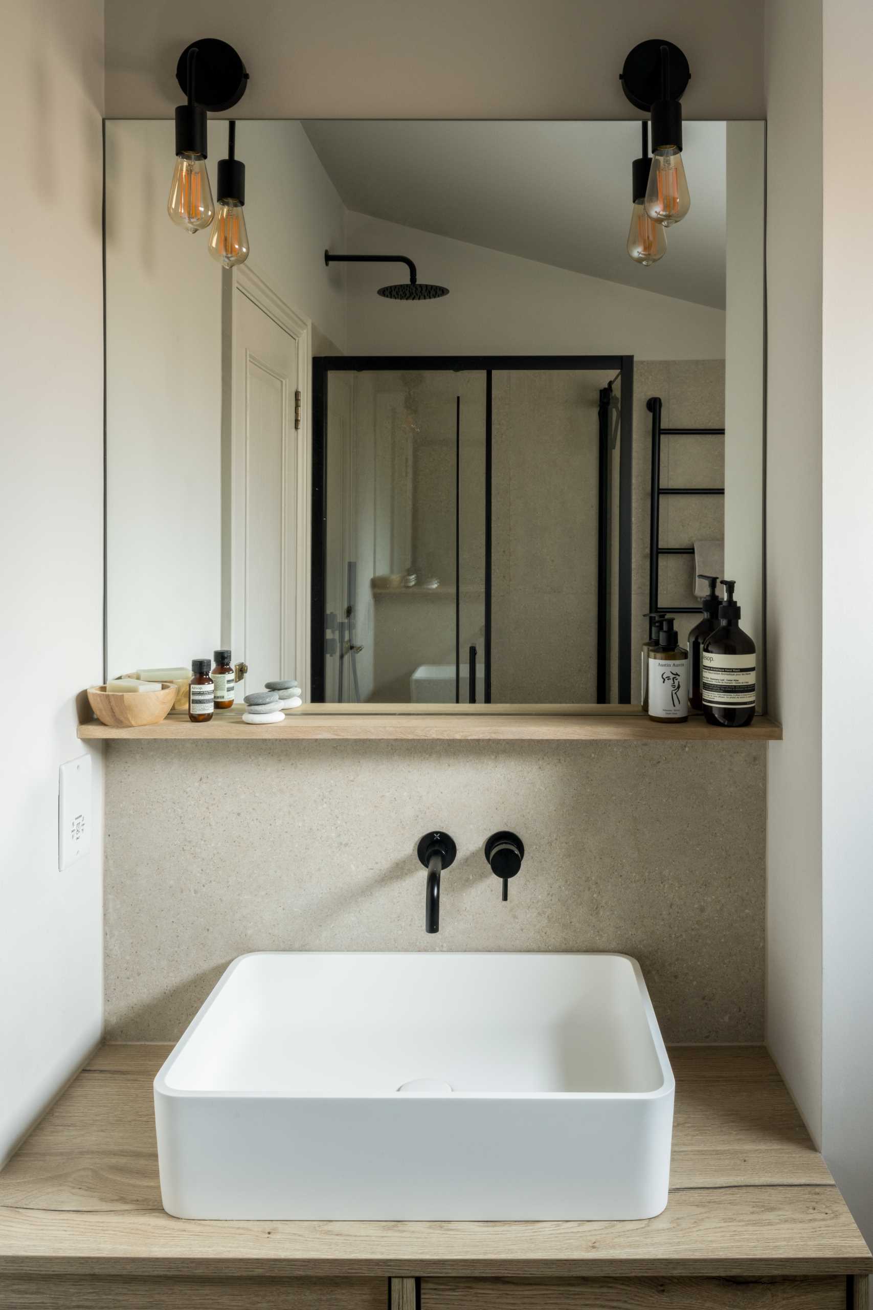 In this bathroom, black accents have been paired with neutral tones for a contemporary look.