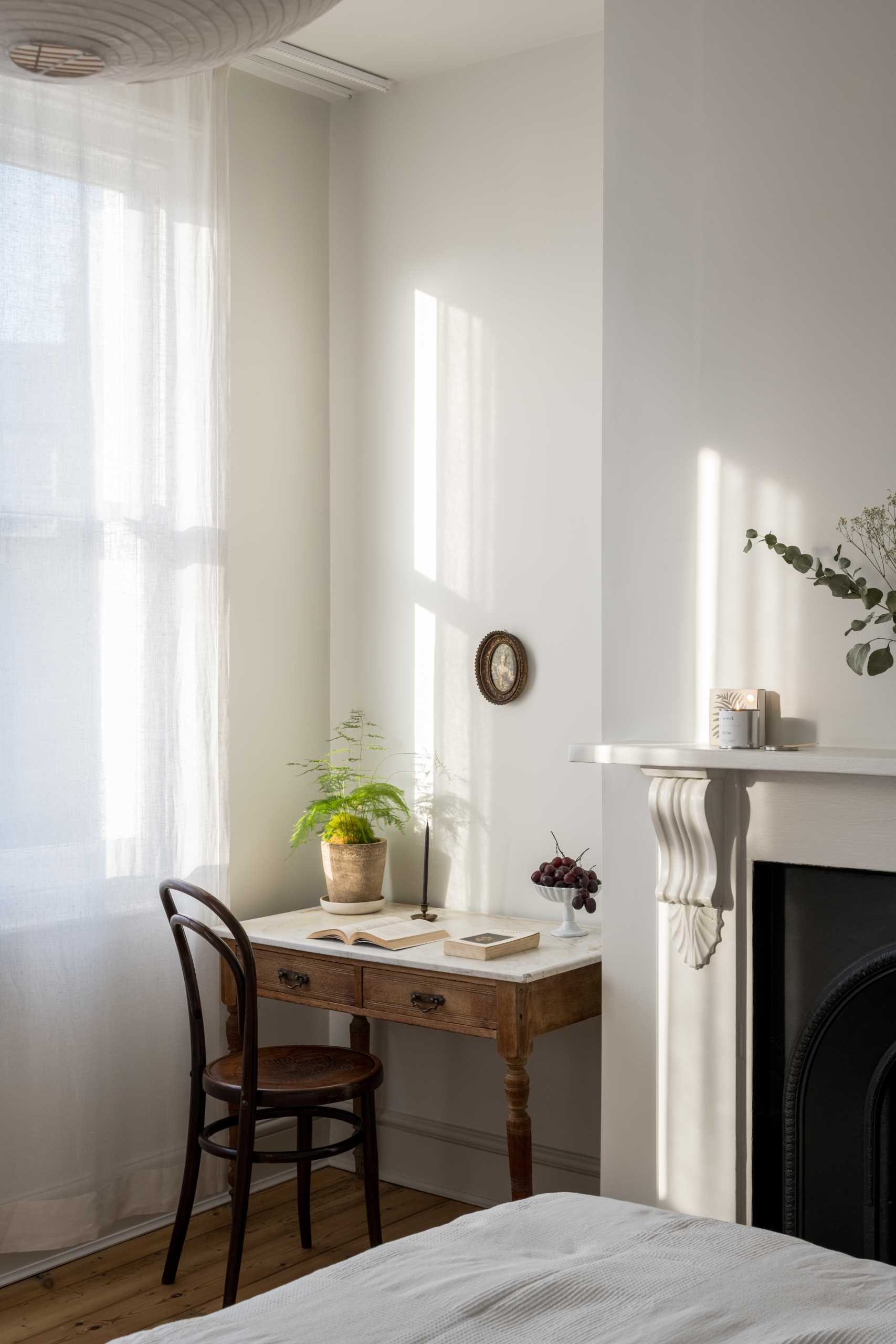 A renovated bedroom retained original elements, like the fireplace.