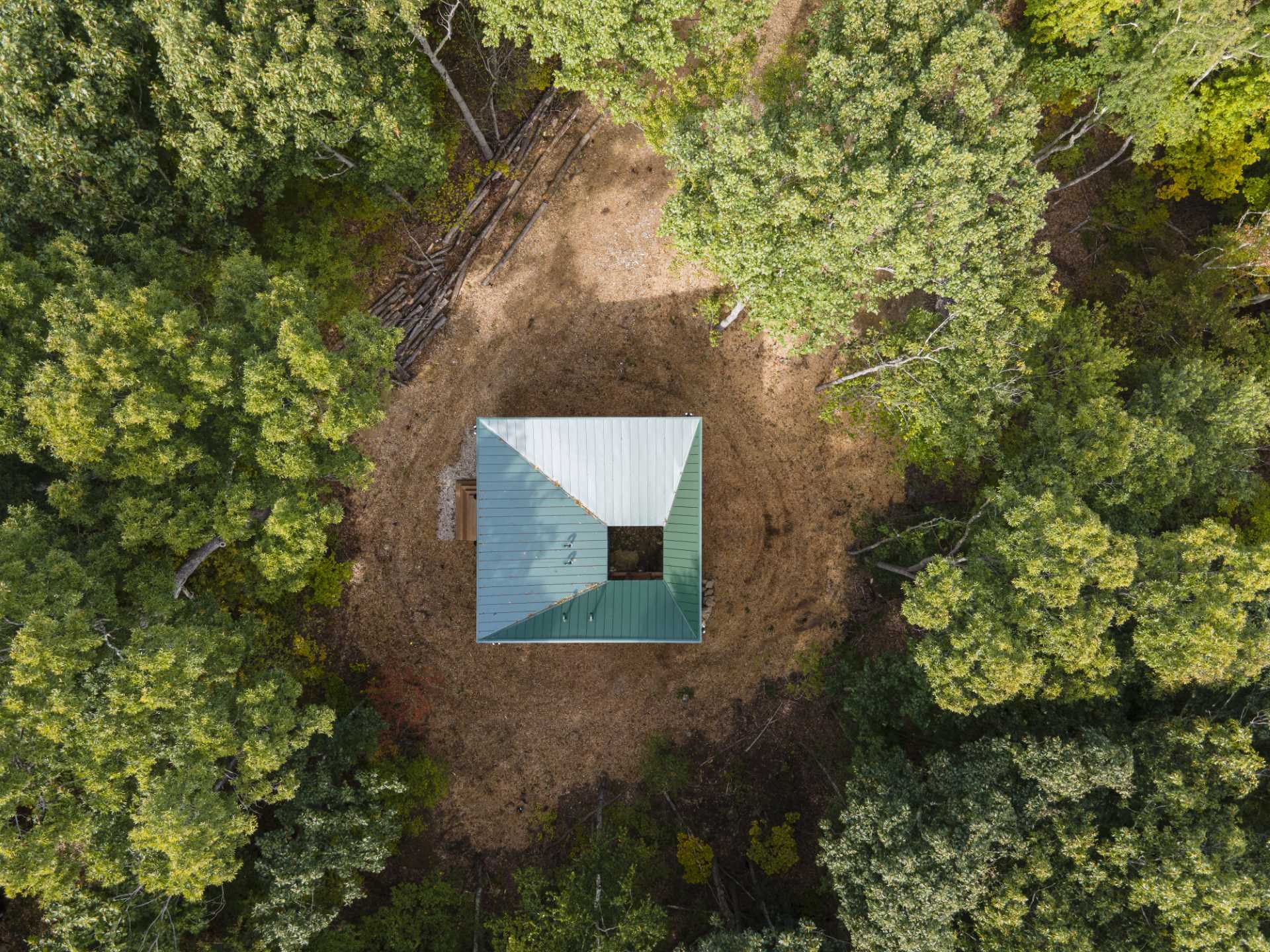 A modern two bedroom cabin with green metal standing seam siding and exposed wood structure.