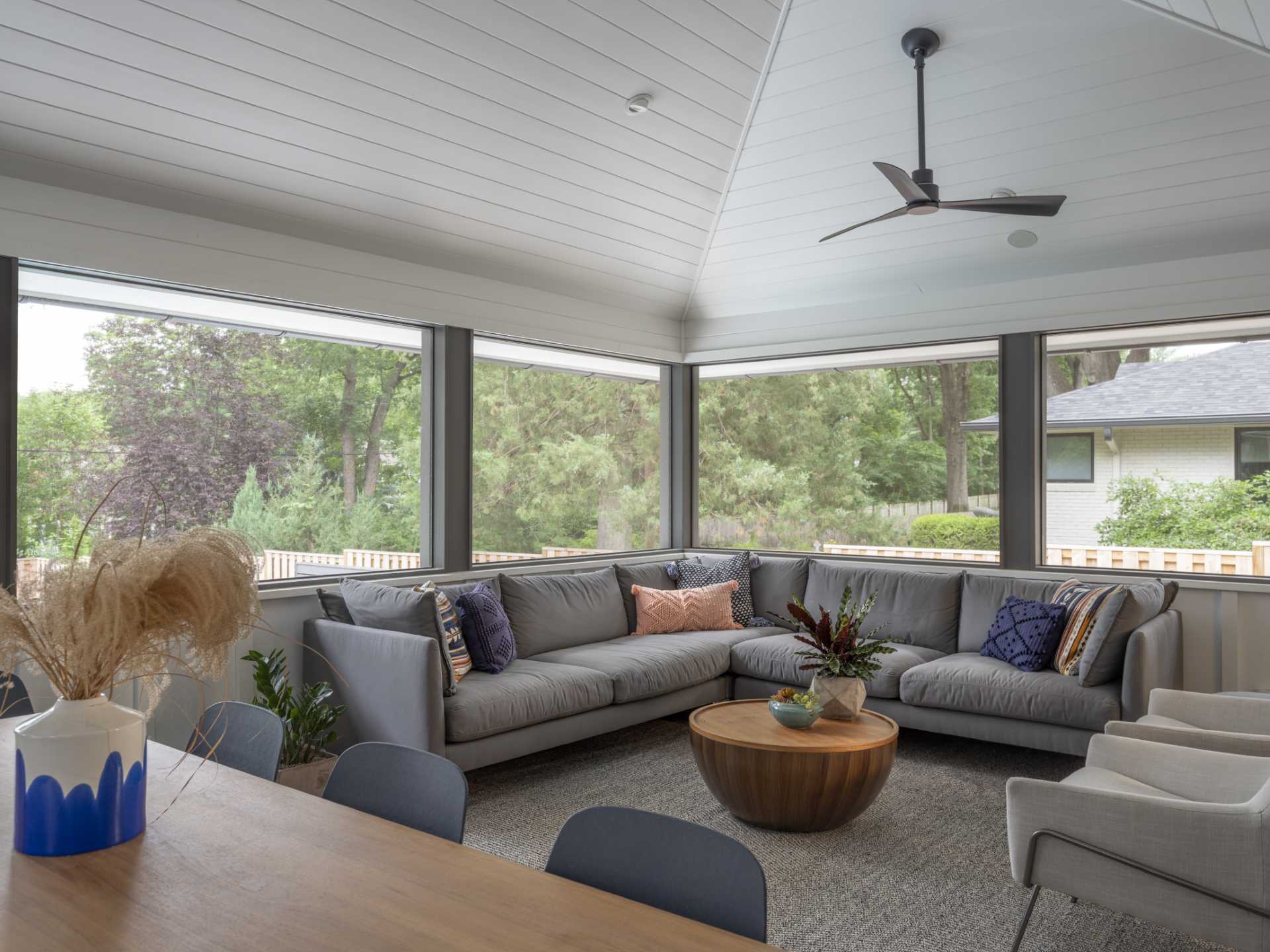 This contemporary home has a screened-in porch with a secondary dining and living area.