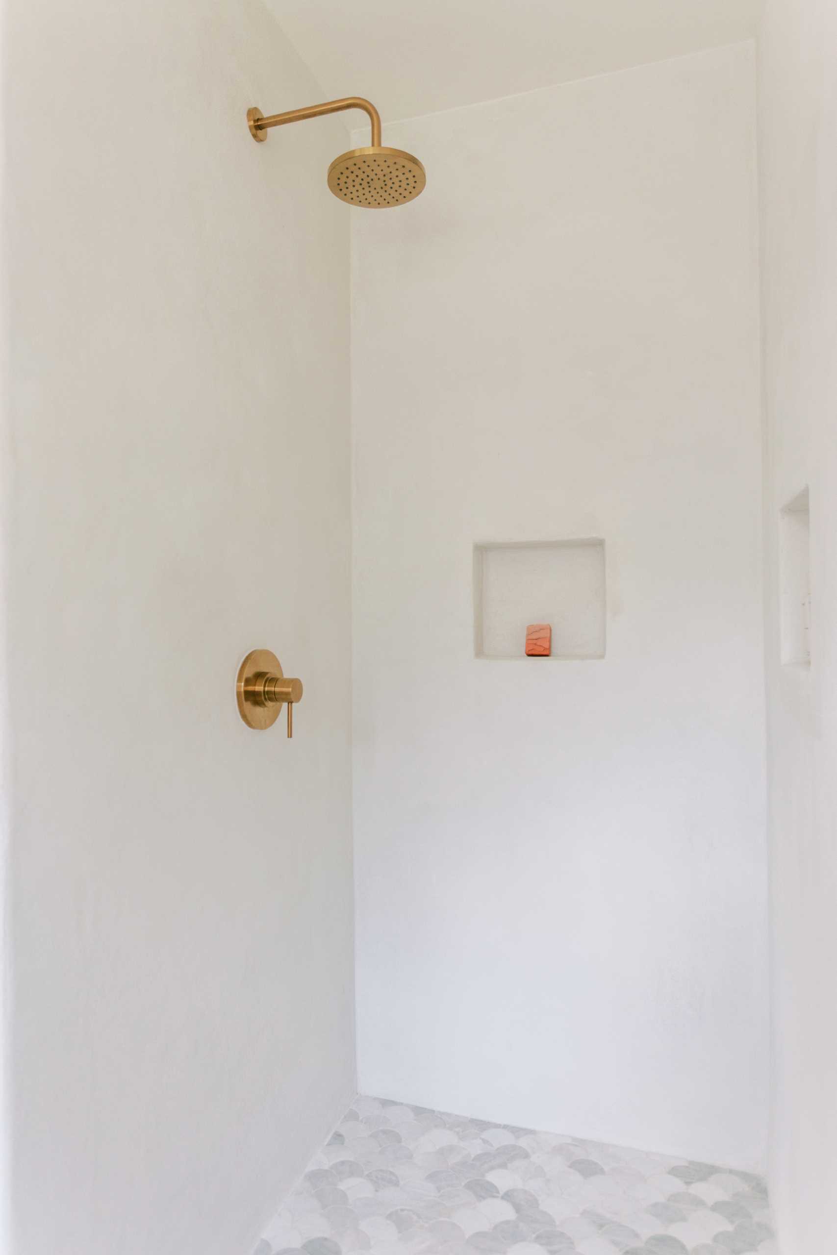 A contemporary shower with shelving niches and fan-shaped floor tiles.