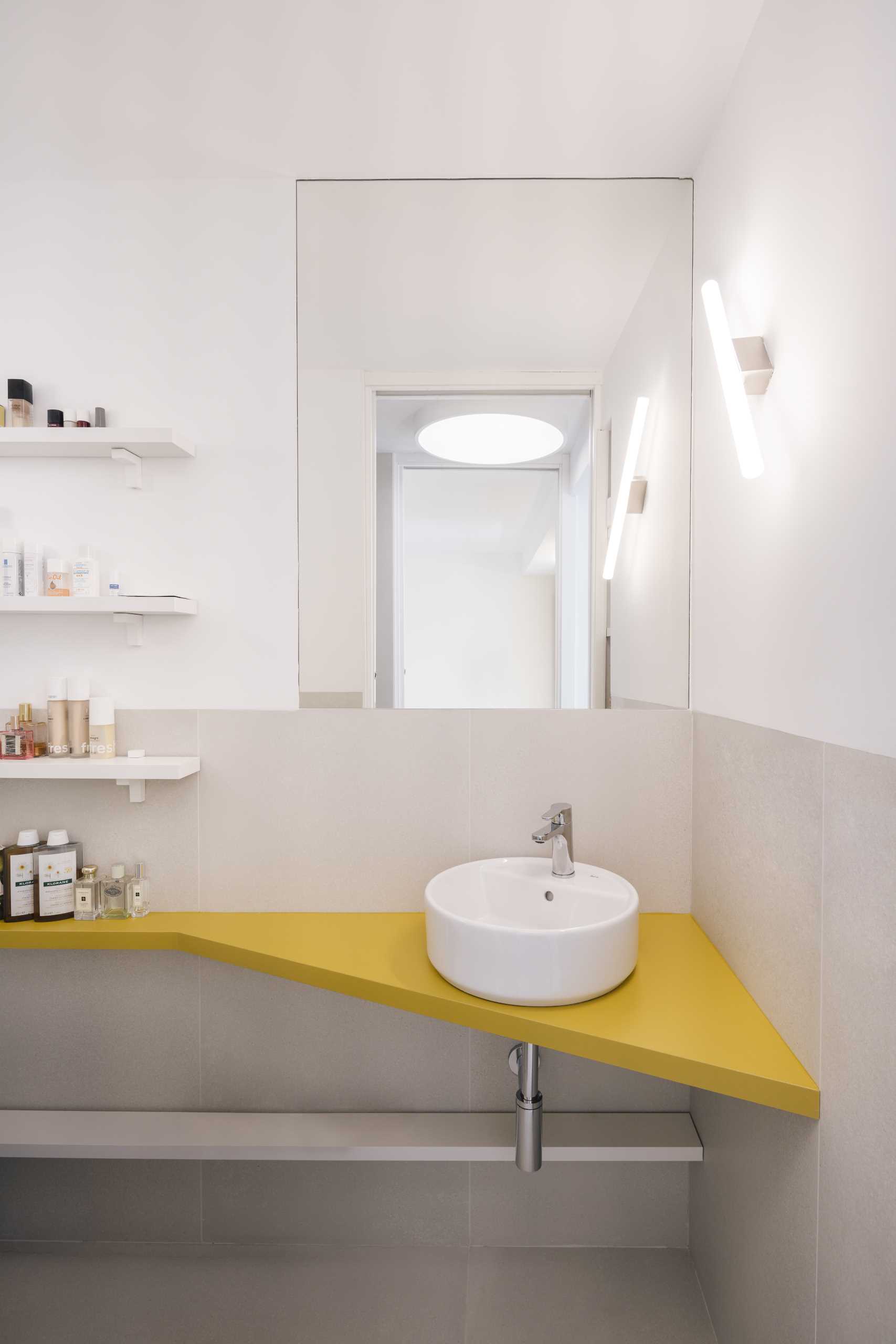 A small bathroom includes a bright yellow vanity.