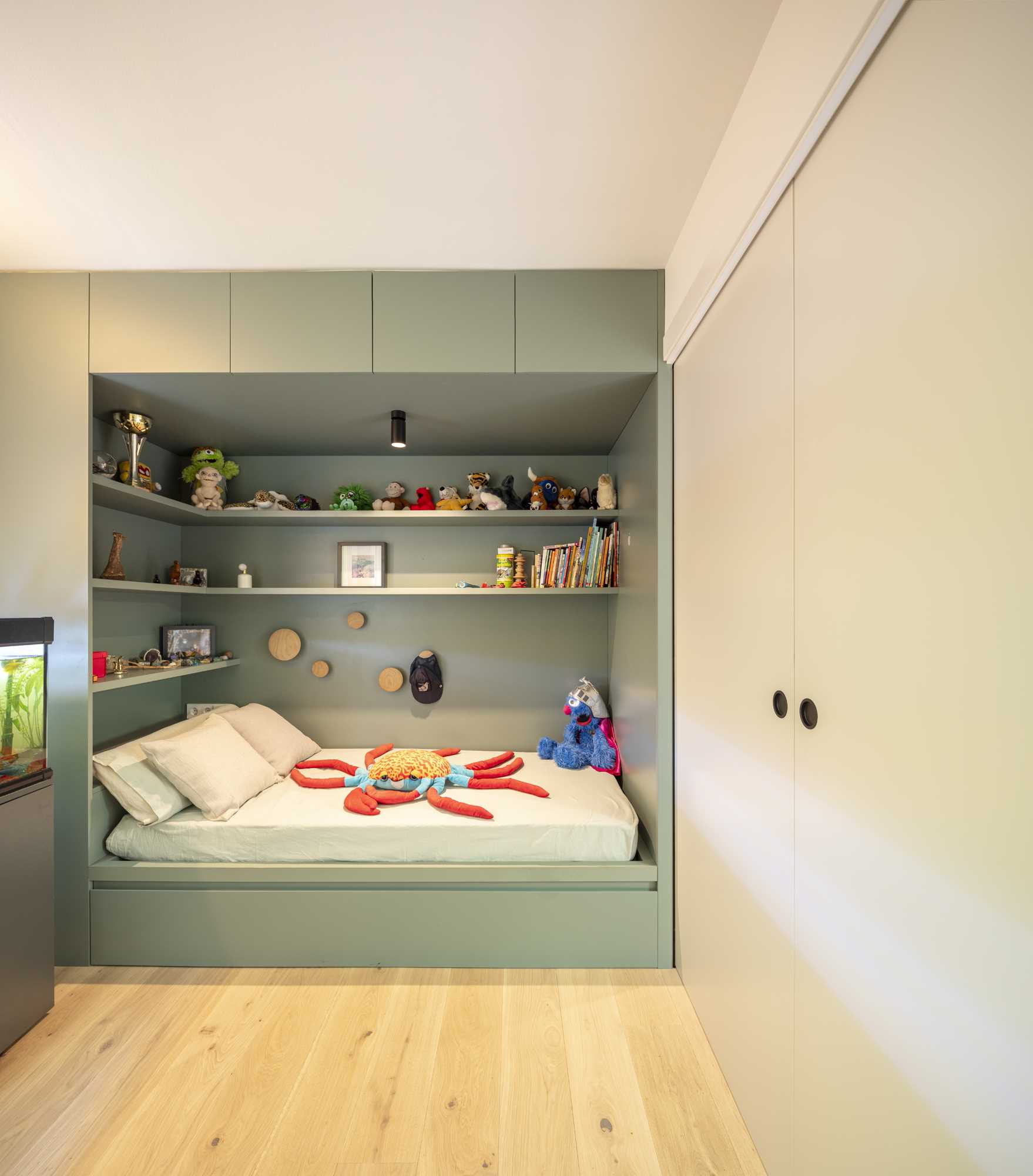 Two kids bedrooms, each with a built-in bed and storage, are connected by sliding doors.