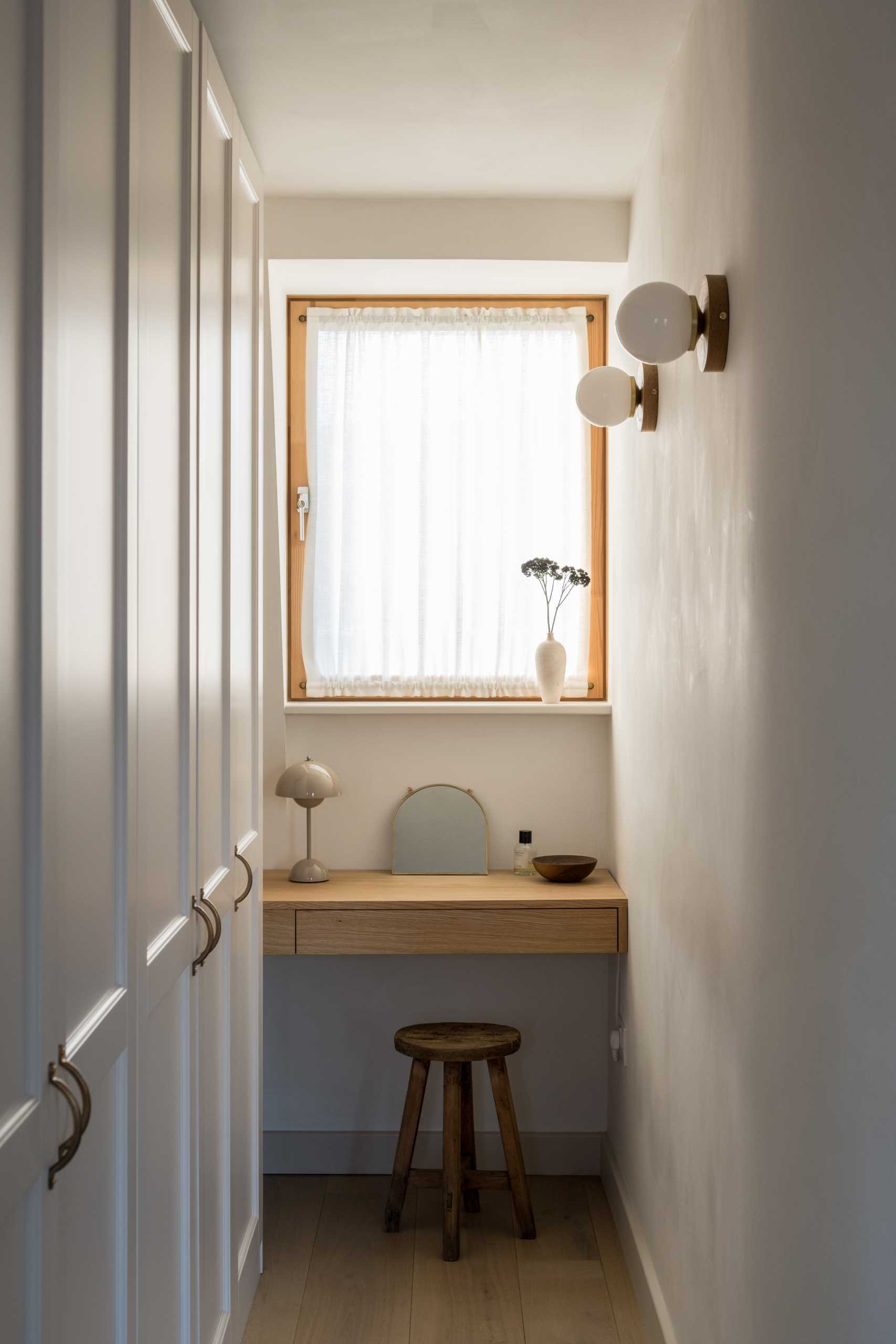 A closet with a small vanity area below the window.