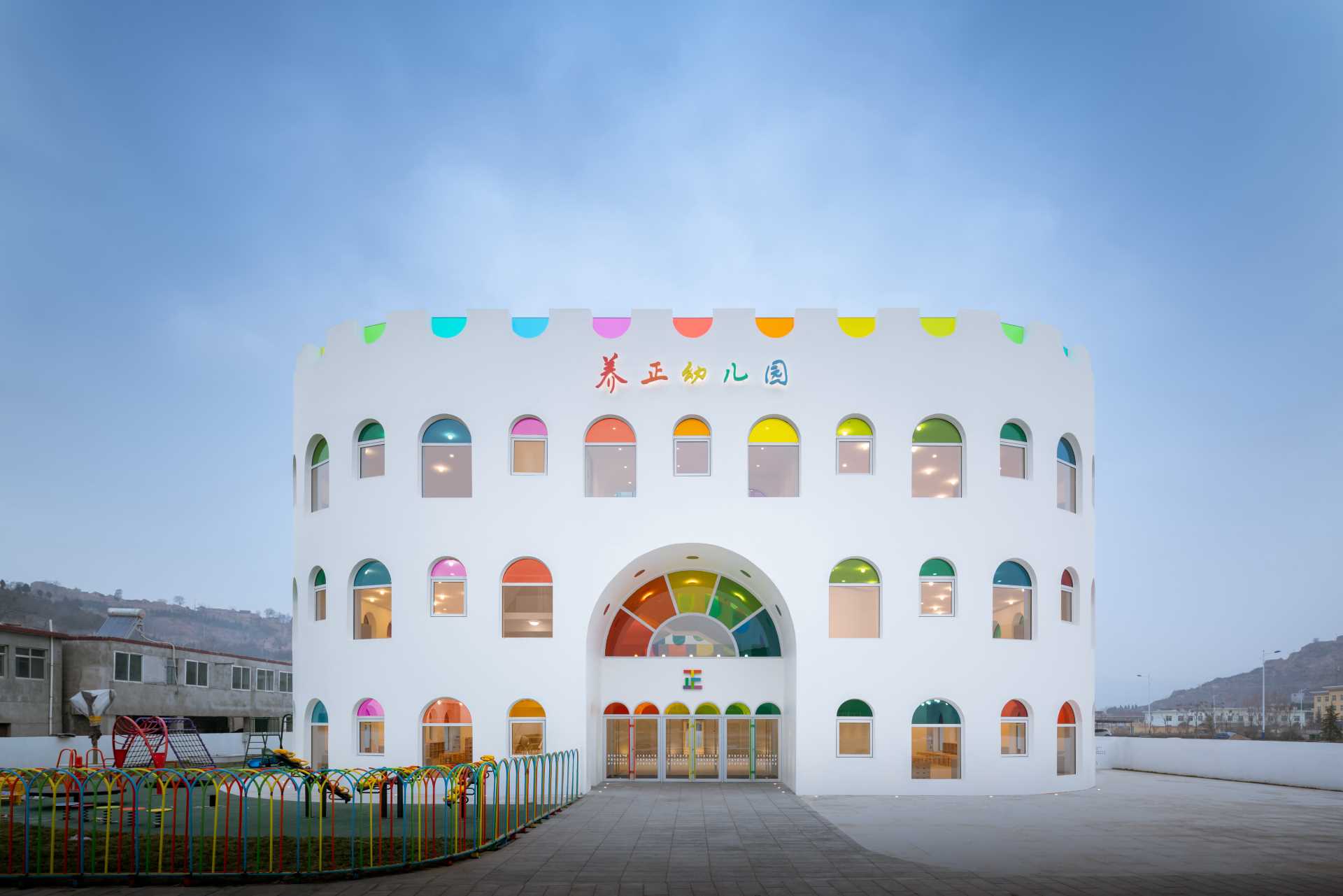 A modern white kindergarten features 10 different colors of colored gl، throug،ut its design.