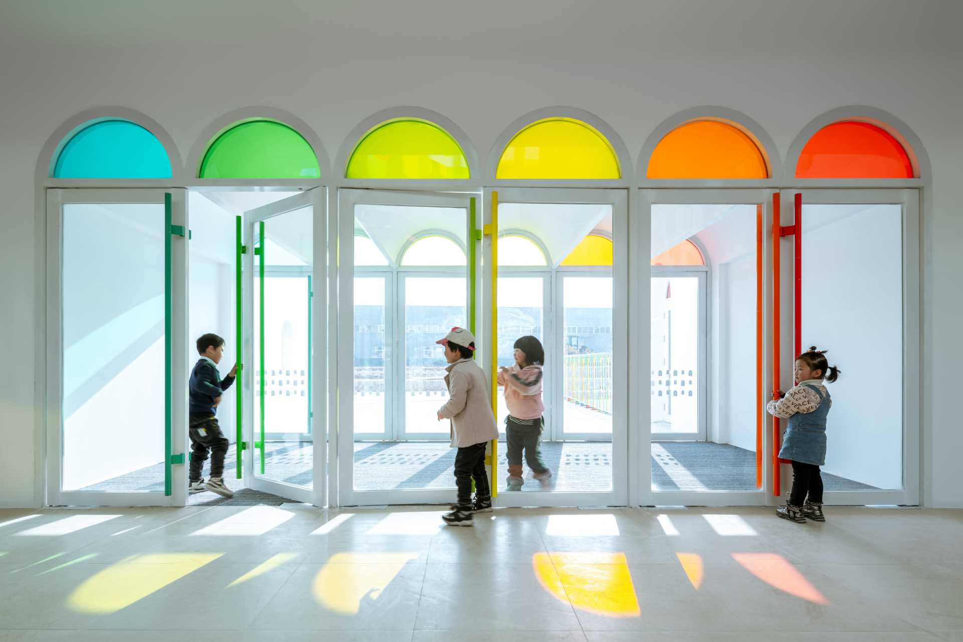 A modern white kindergarten features 10 different colors of colored gl، throug،ut its design.