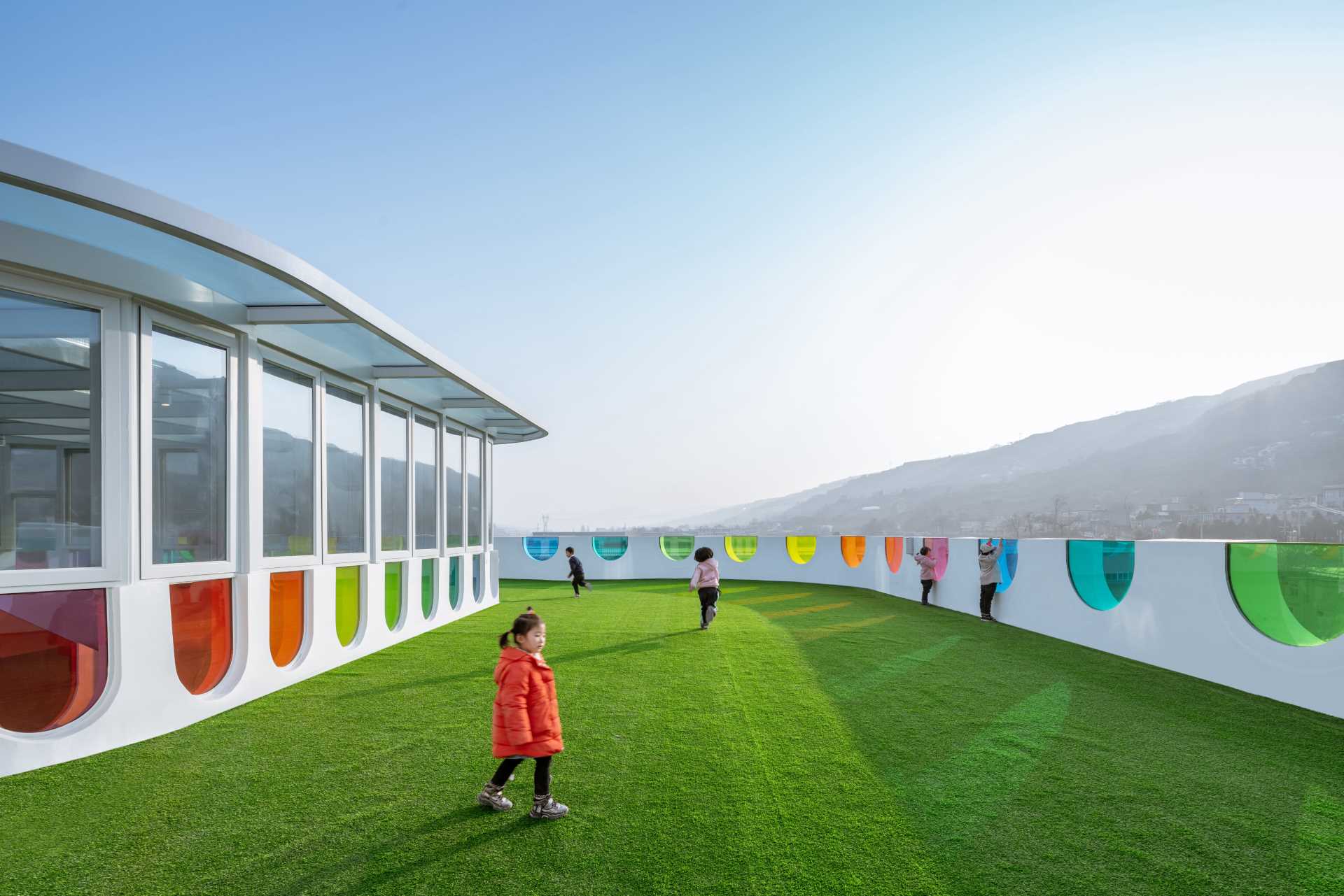 A modern white kindergarten features 10 different colors of colored glass throughout its design.