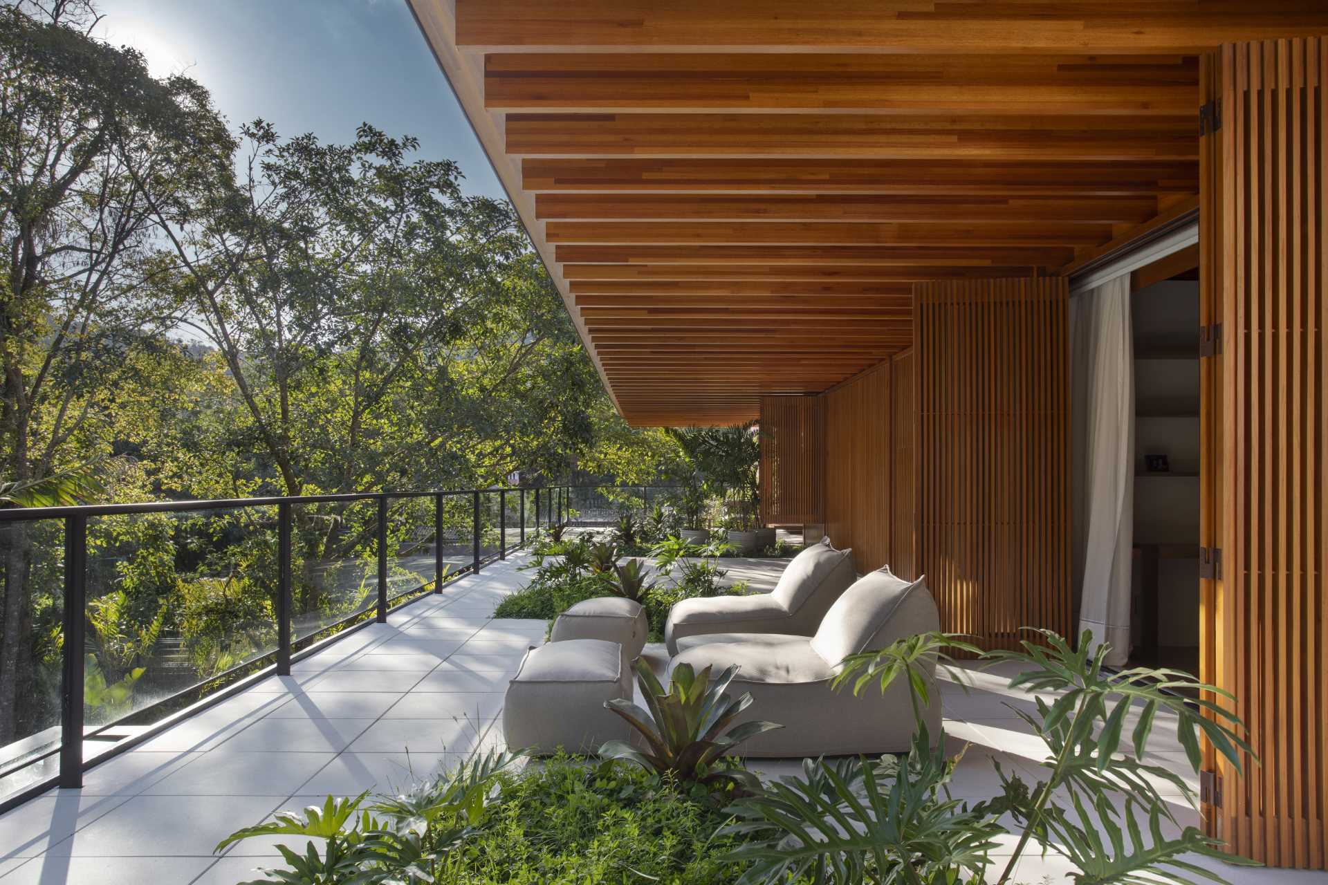 In this modern bedrooms, a sliding glass door opens the room to a balcony that's covered by the overhanging roof.