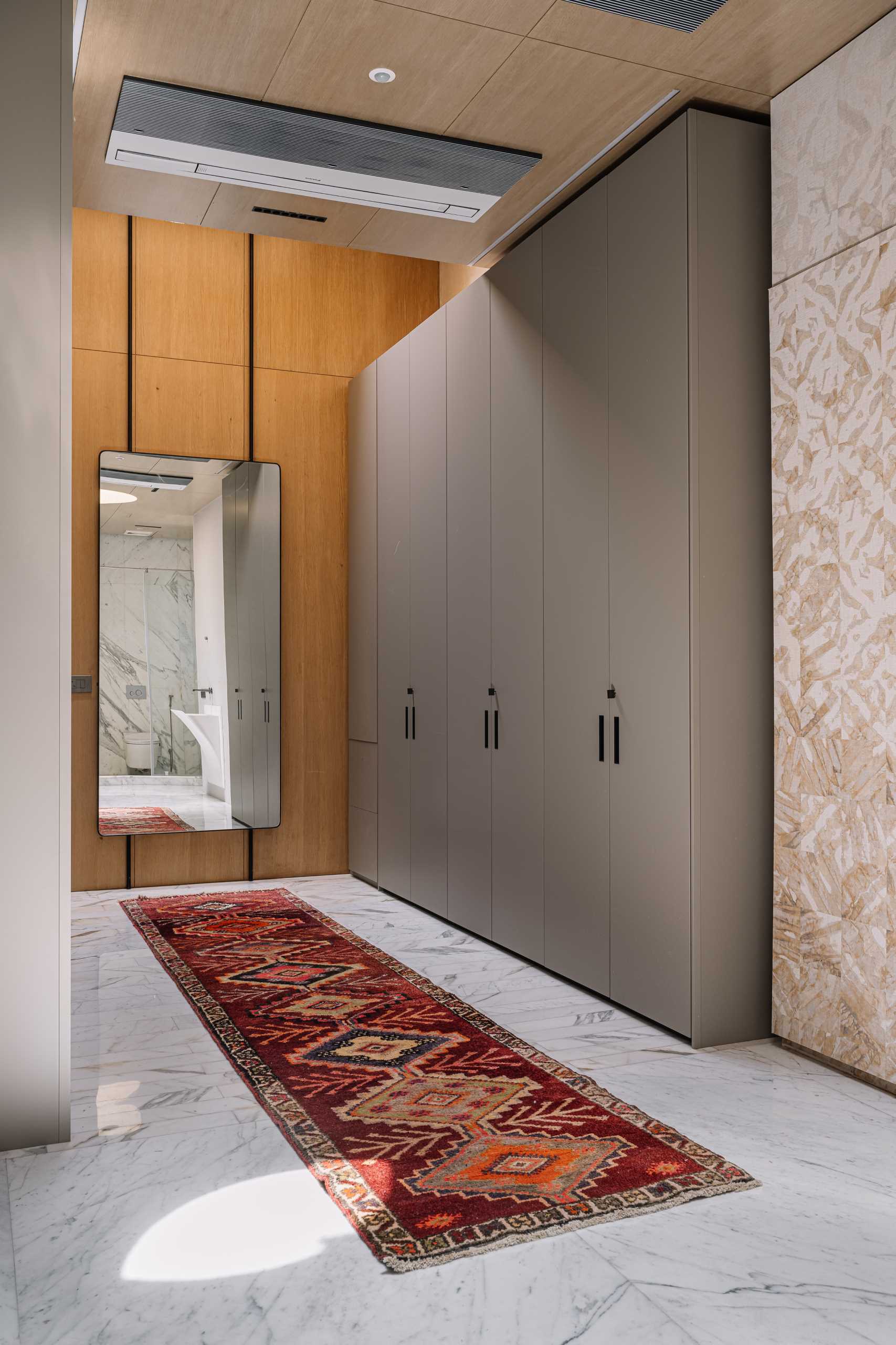 A modern bathroom with high ceilings and lots of storage.