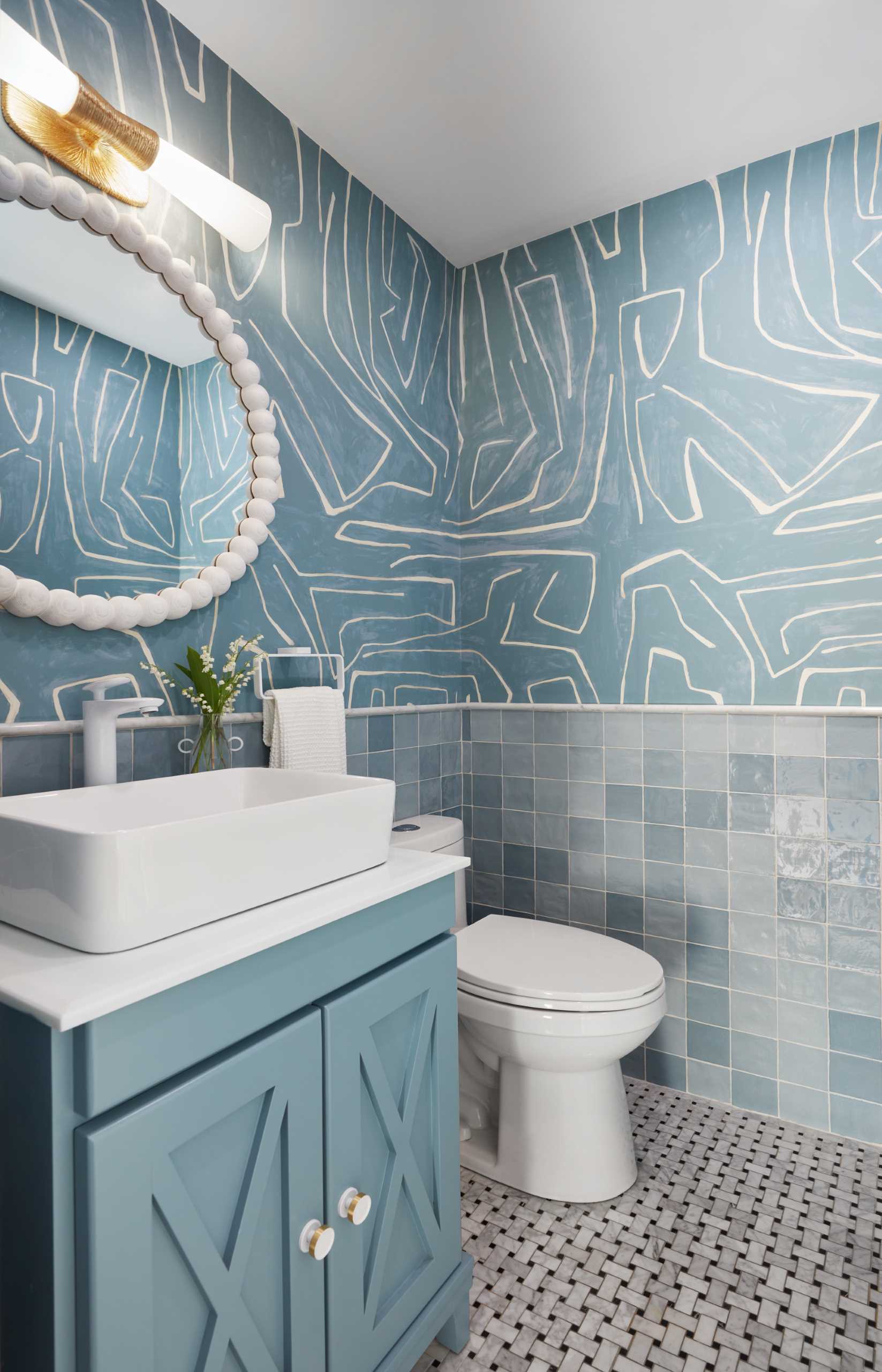 In this contemporary bathroom, graphic wallpaper covers the walls and the white accents help to keep the interior bright.