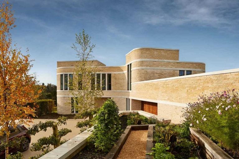 Stone Snakes Around The Curved Exterior Of This Modern Home