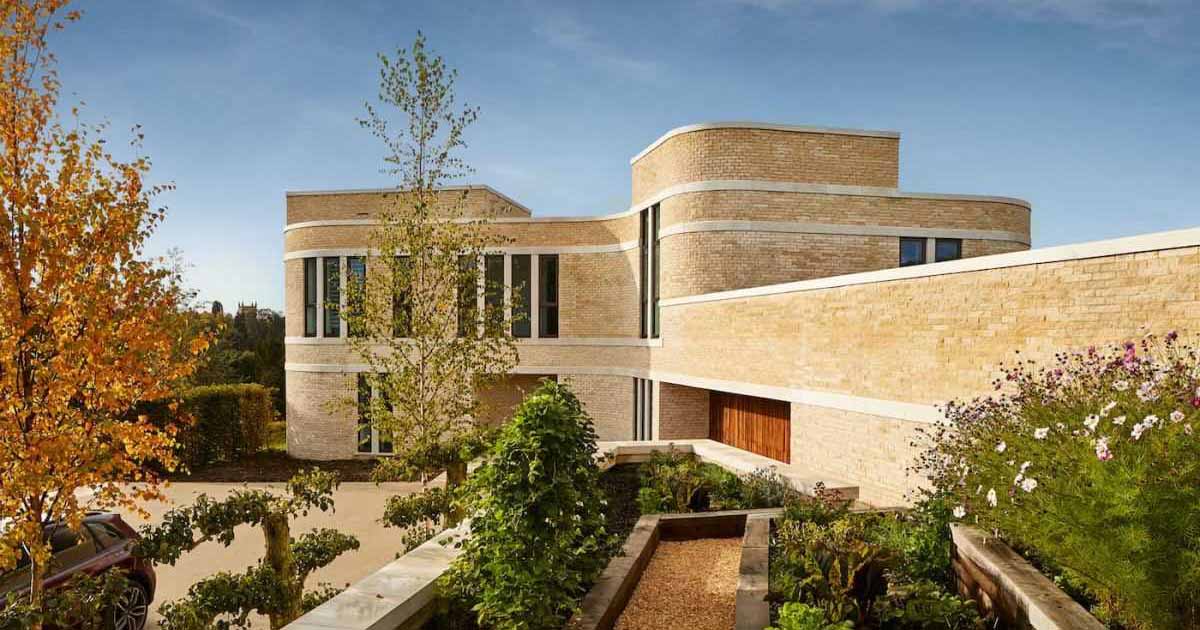 Stone Snakes Around The Curved Exterior Of This Modern Home