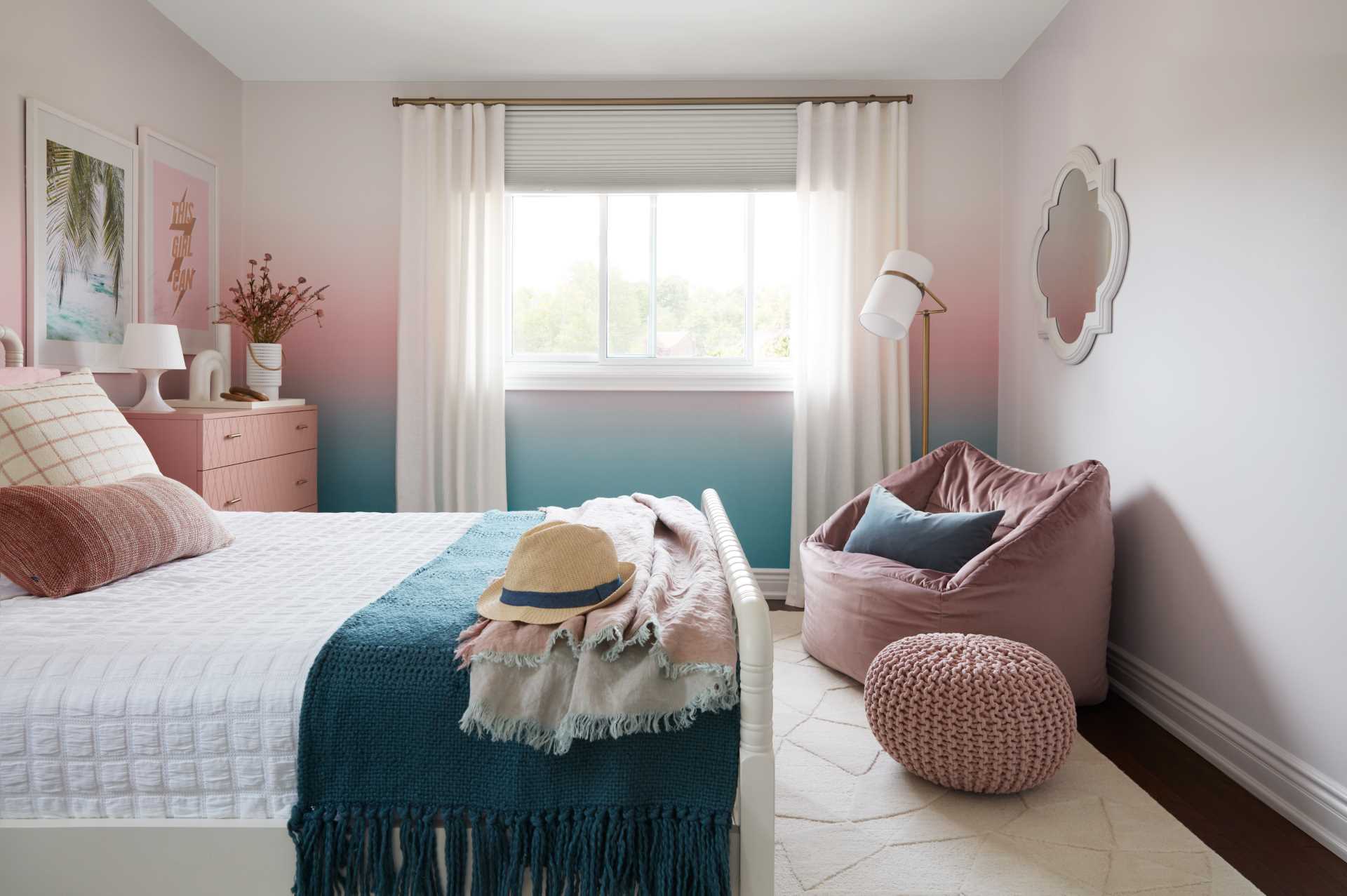 A colorful bedroom includes blue-to-pink ombre wallpaper with matching furniture and accessories.