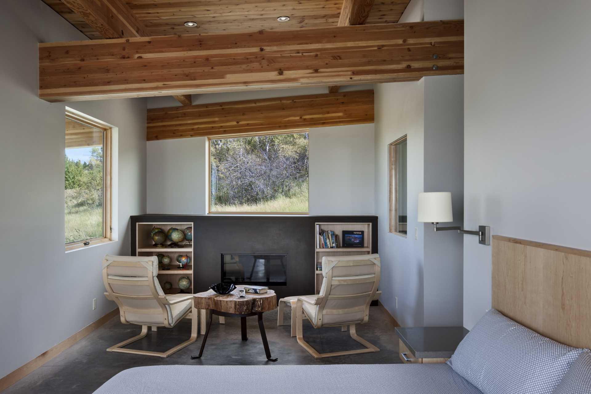 In this bedroom, there's a sitting area with a fireplace, while the structural wood beams can easily be seen.