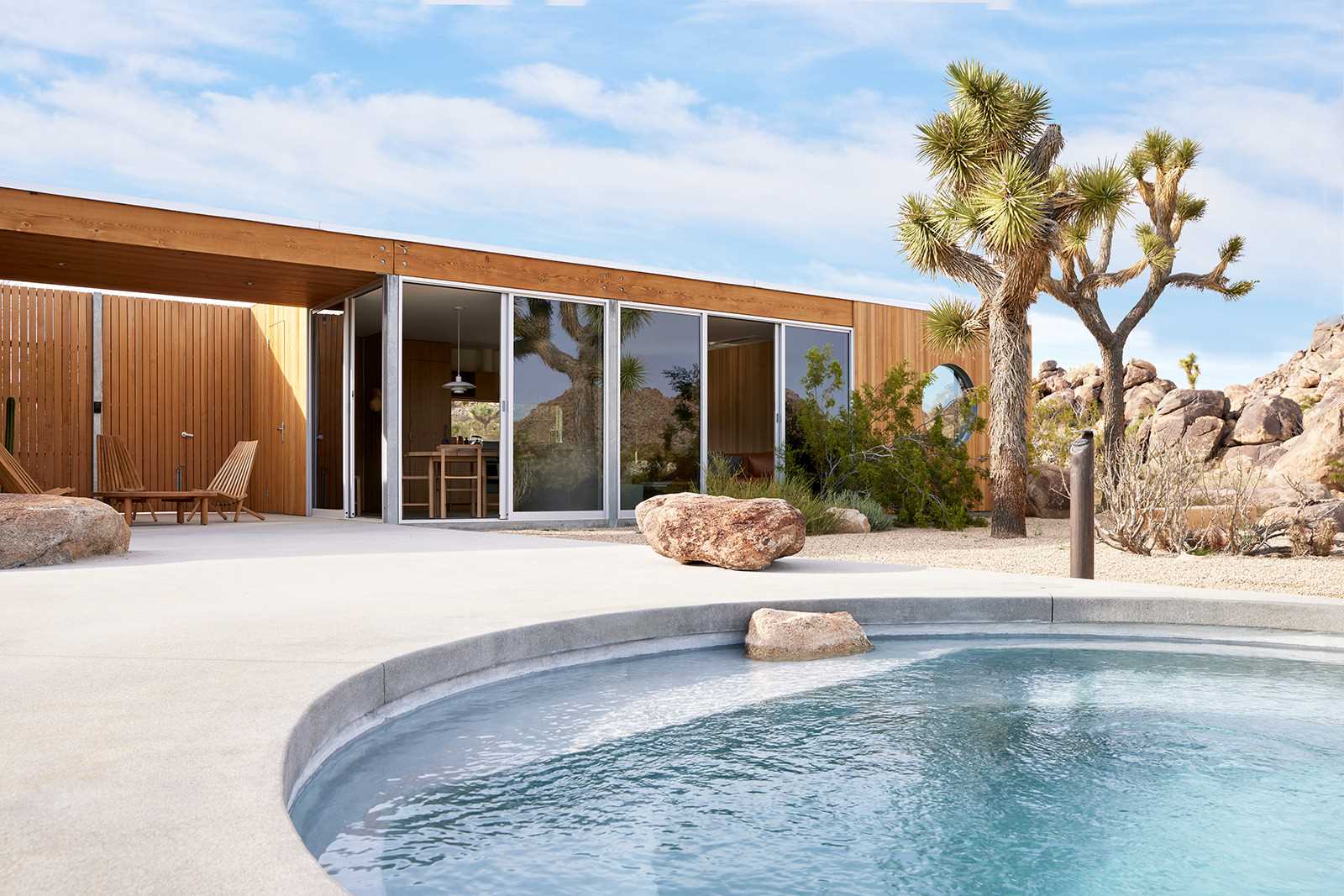 A desert home with wood siding that blends into its surrounding.