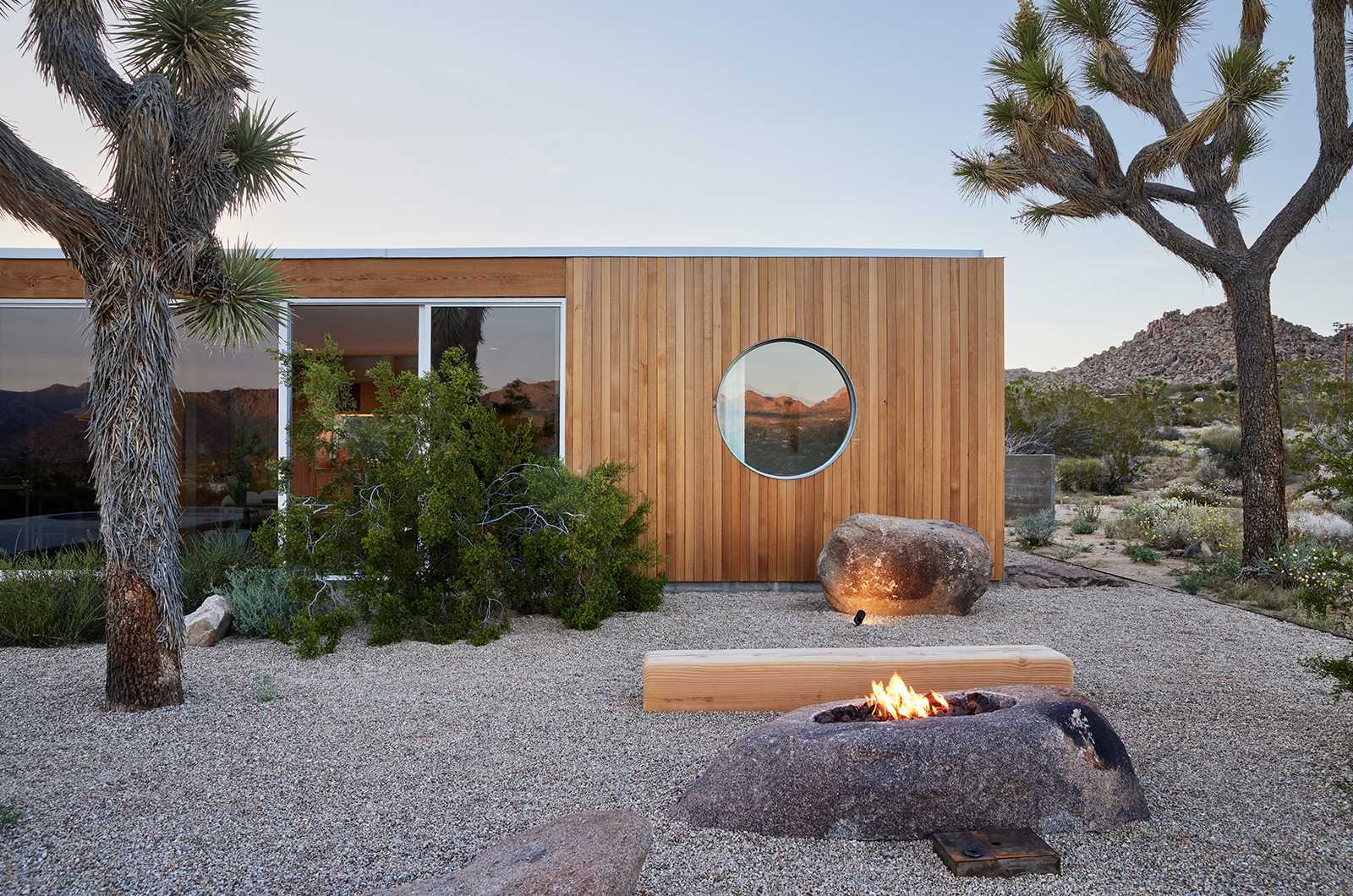 A desert home with wood siding that blends into its surrounding.