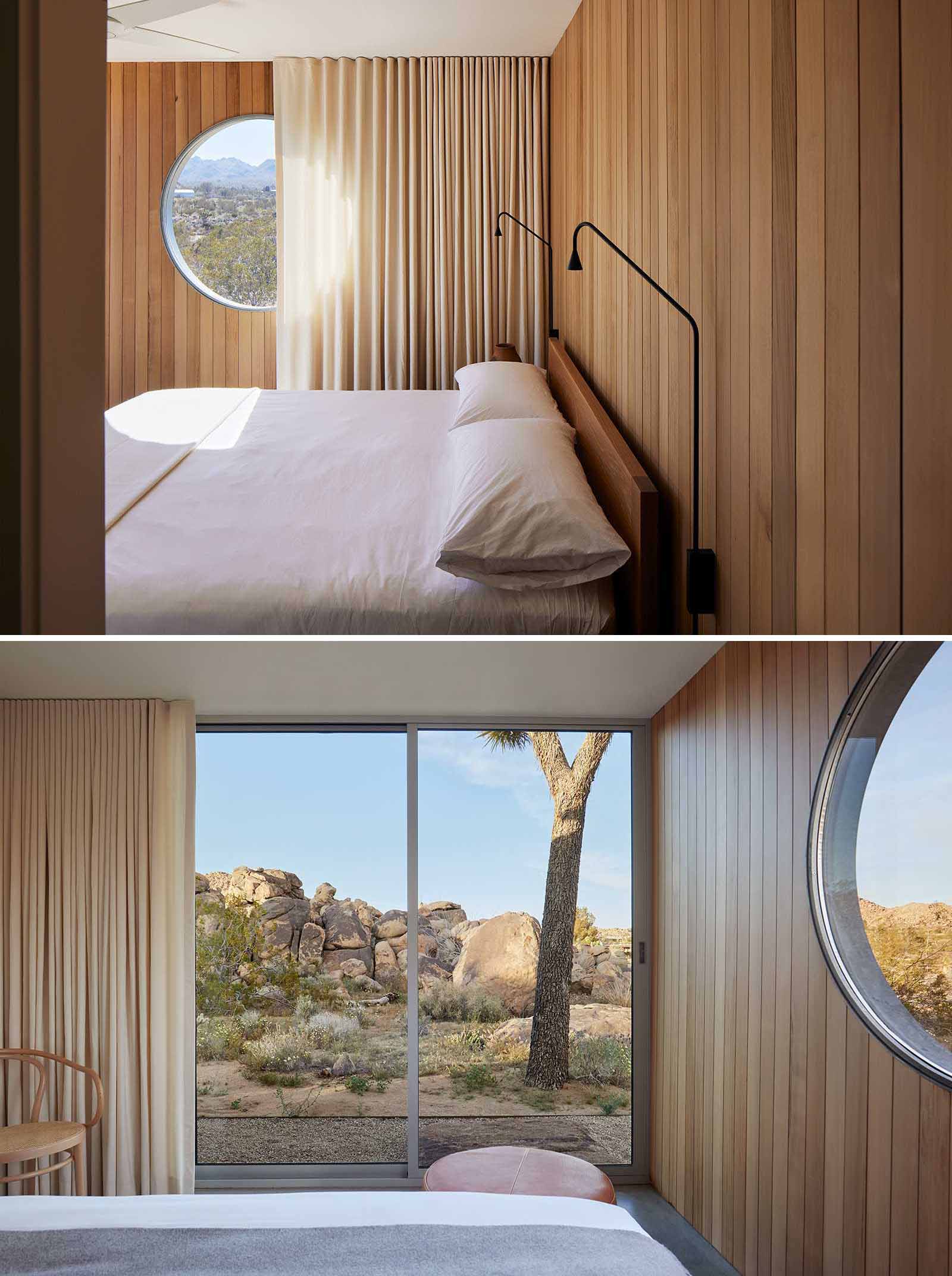 This modern bedroom includes a uniquely-designed round window, while cedar wall paneling covers the walls.