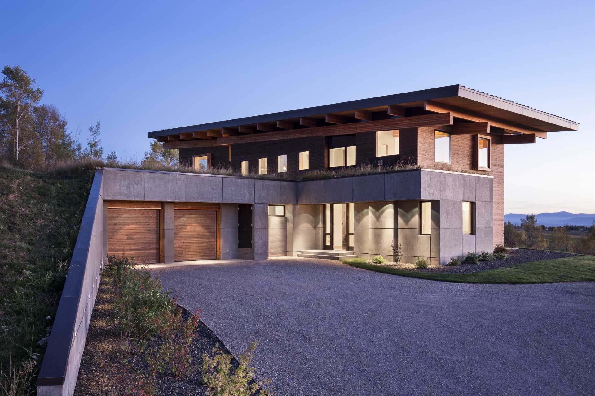 A green roof above the garage helps the home blend into the hillside.