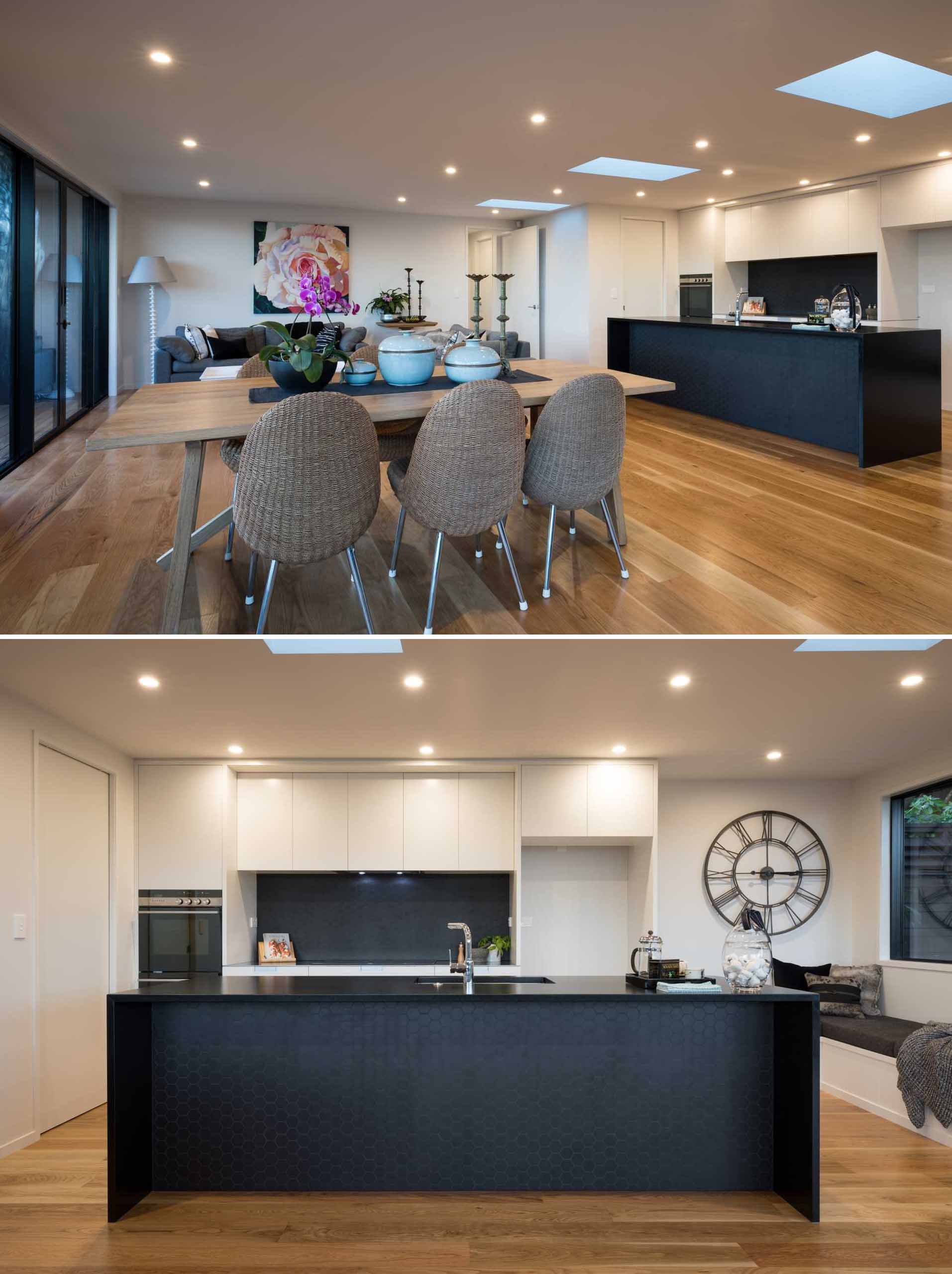 Inside this renovated home, the main social areas of the home are open plan, with the living room, dining area, and kitchen sharing the space. Skylights add even more natural light to the space.