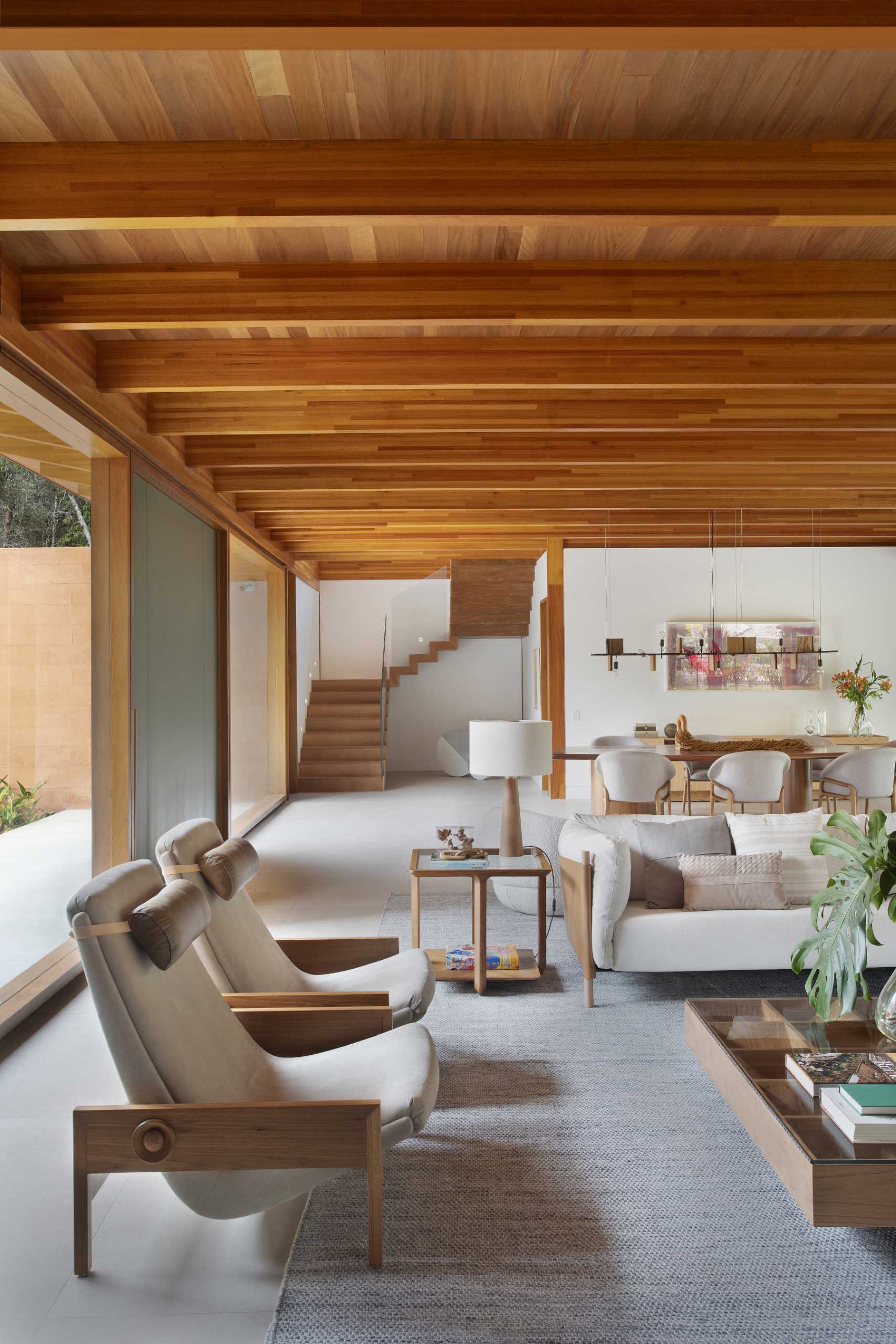 Wood stairs with a glass handrail connect the main social areas of the home with the private bedrooms upstairs.