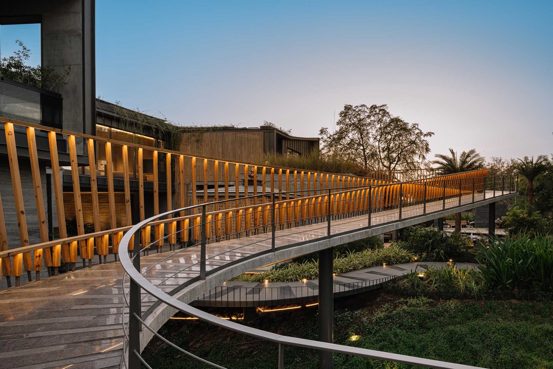 A curving bridge walkway leads to various outdoor entertaining areas of this modern home designed for multi-generational living.