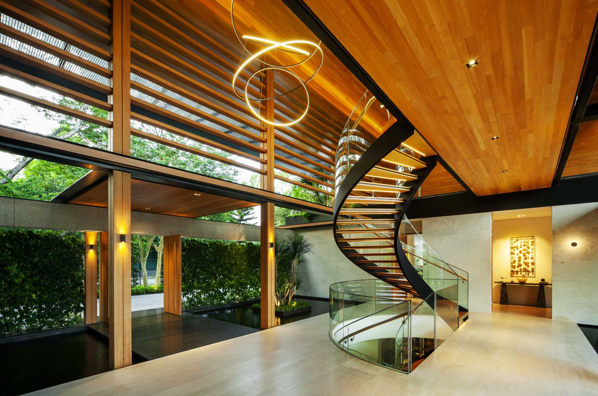 A modern house with plenty of greenery and water features that help keep the home cool.