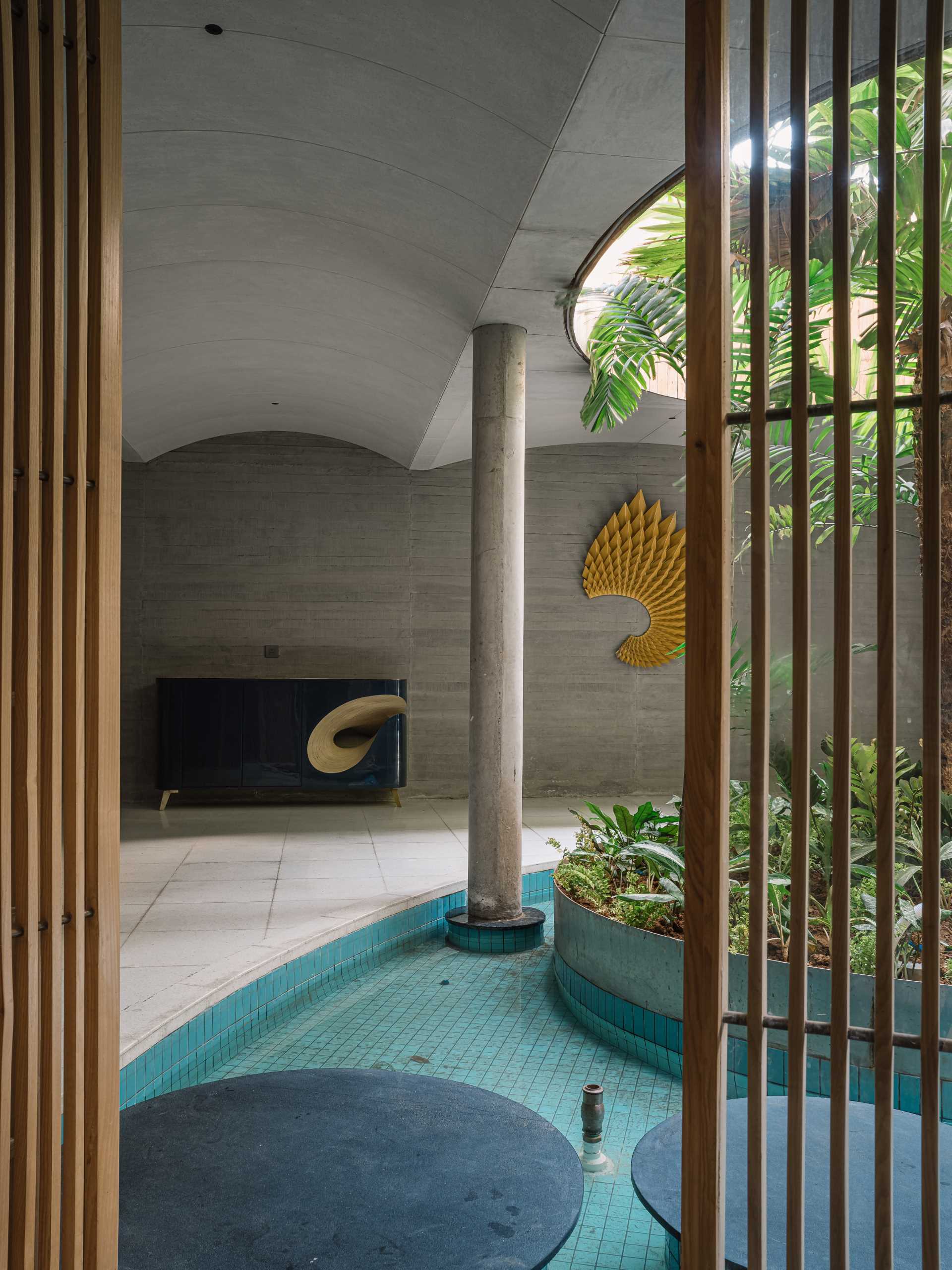 A quiet area of this modern home includes a massage room, a water feature with a garden island, and a sculptural wall.