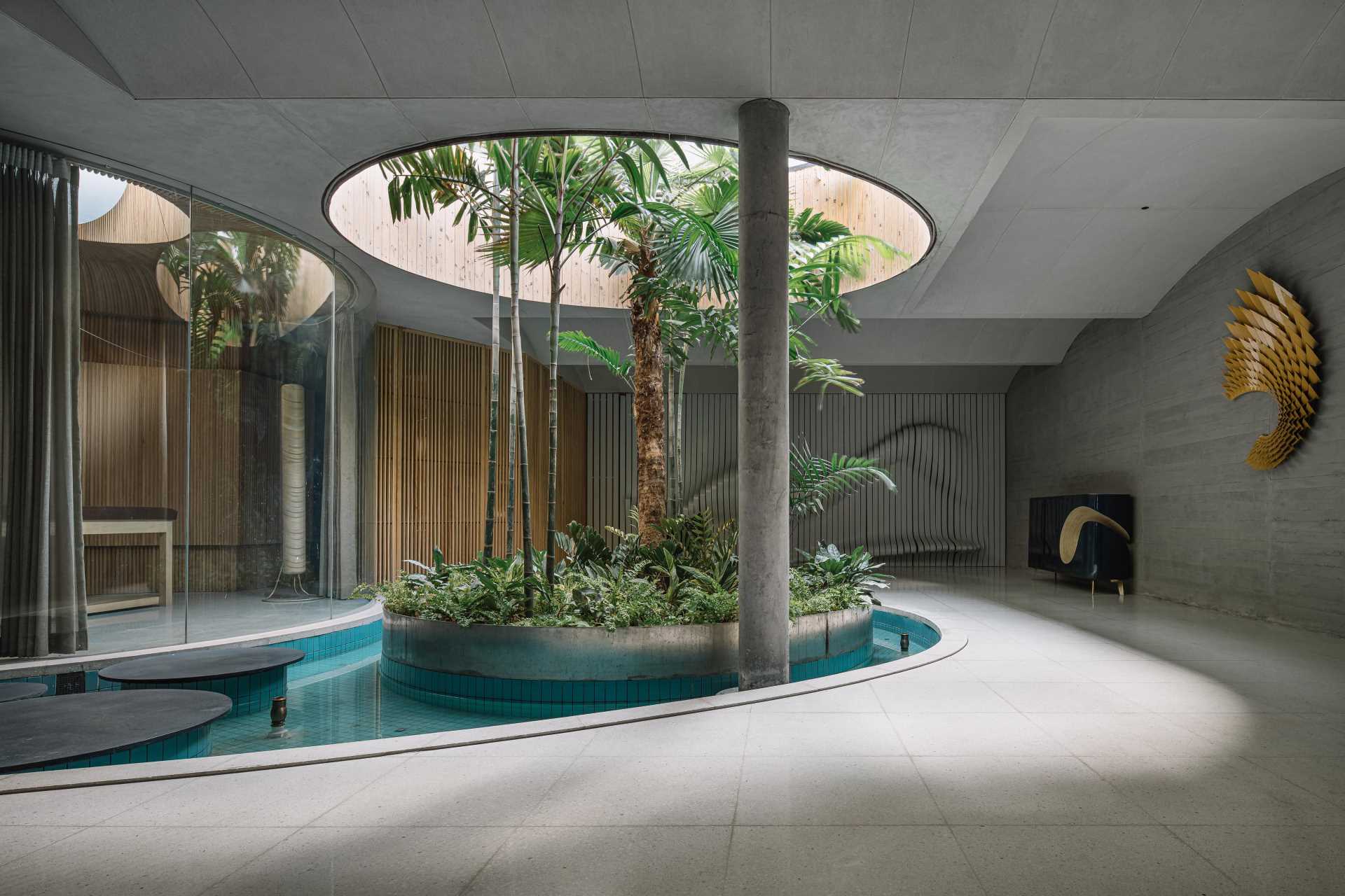 A quiet area of this modern home includes a massage room, a water feature with a garden island, and a sculptural wall.