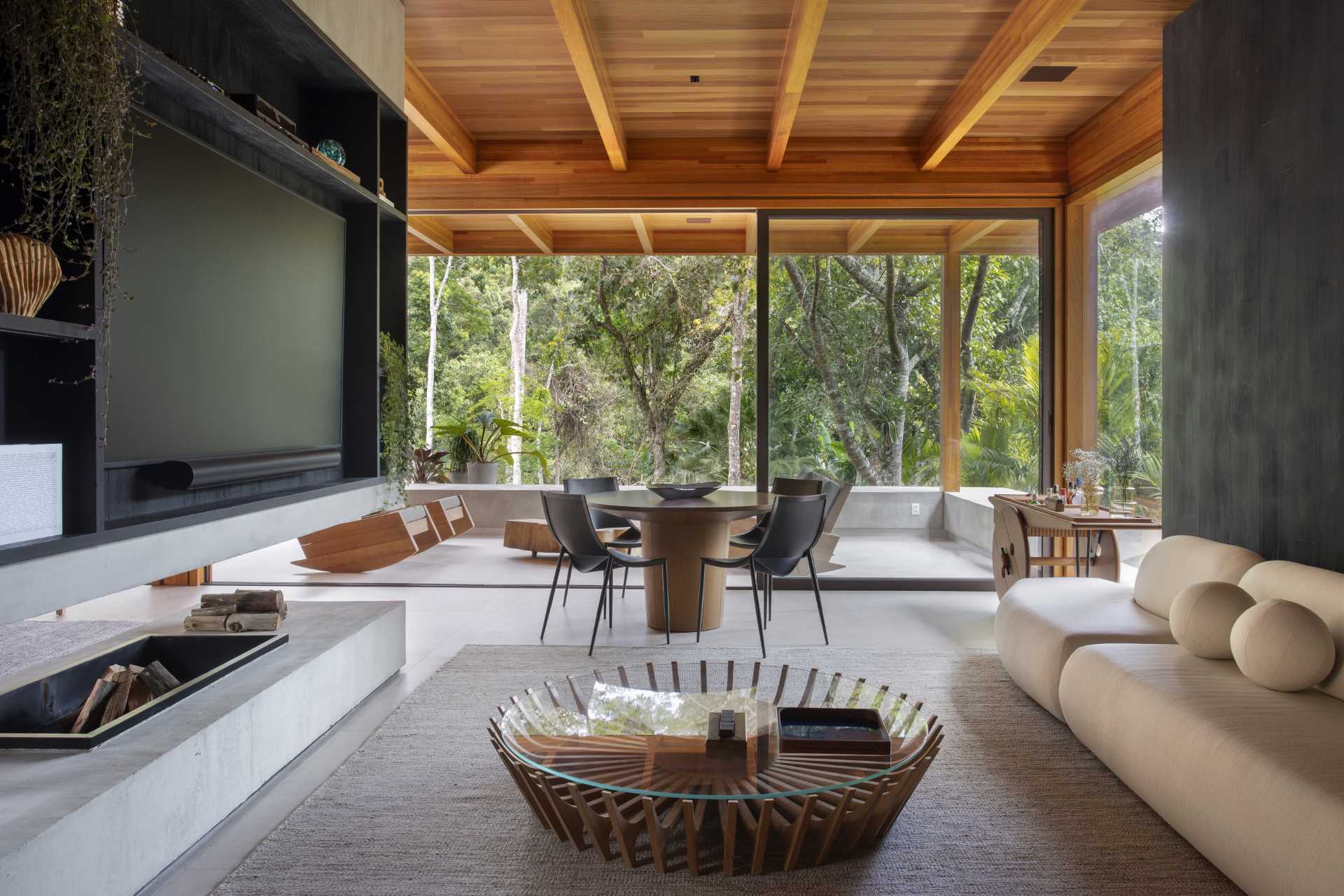 In this modern TV room, there's a dark wood accent wall made from Muiracatiara wood slats finished with a Shou Sugi Ban treatment.