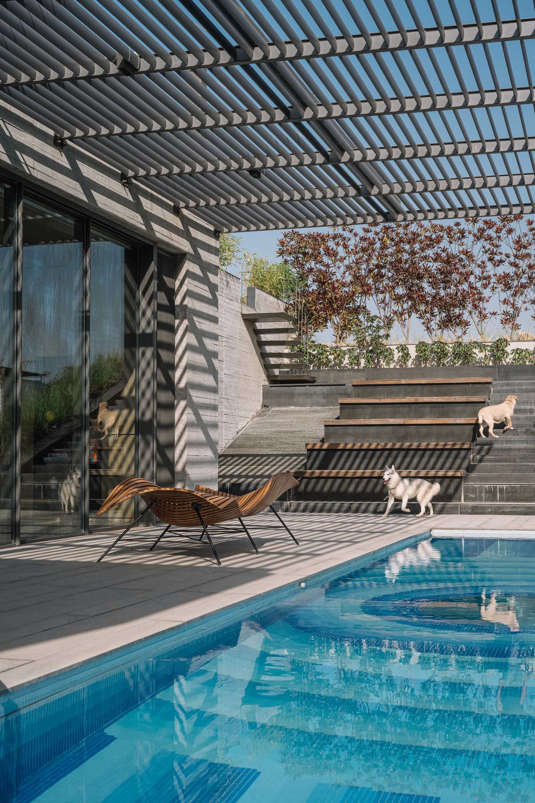 A decorative pattern of various blue shades lines the bottom of the pool, while the center of the pool has a window that shows the covered outdoor space below. 