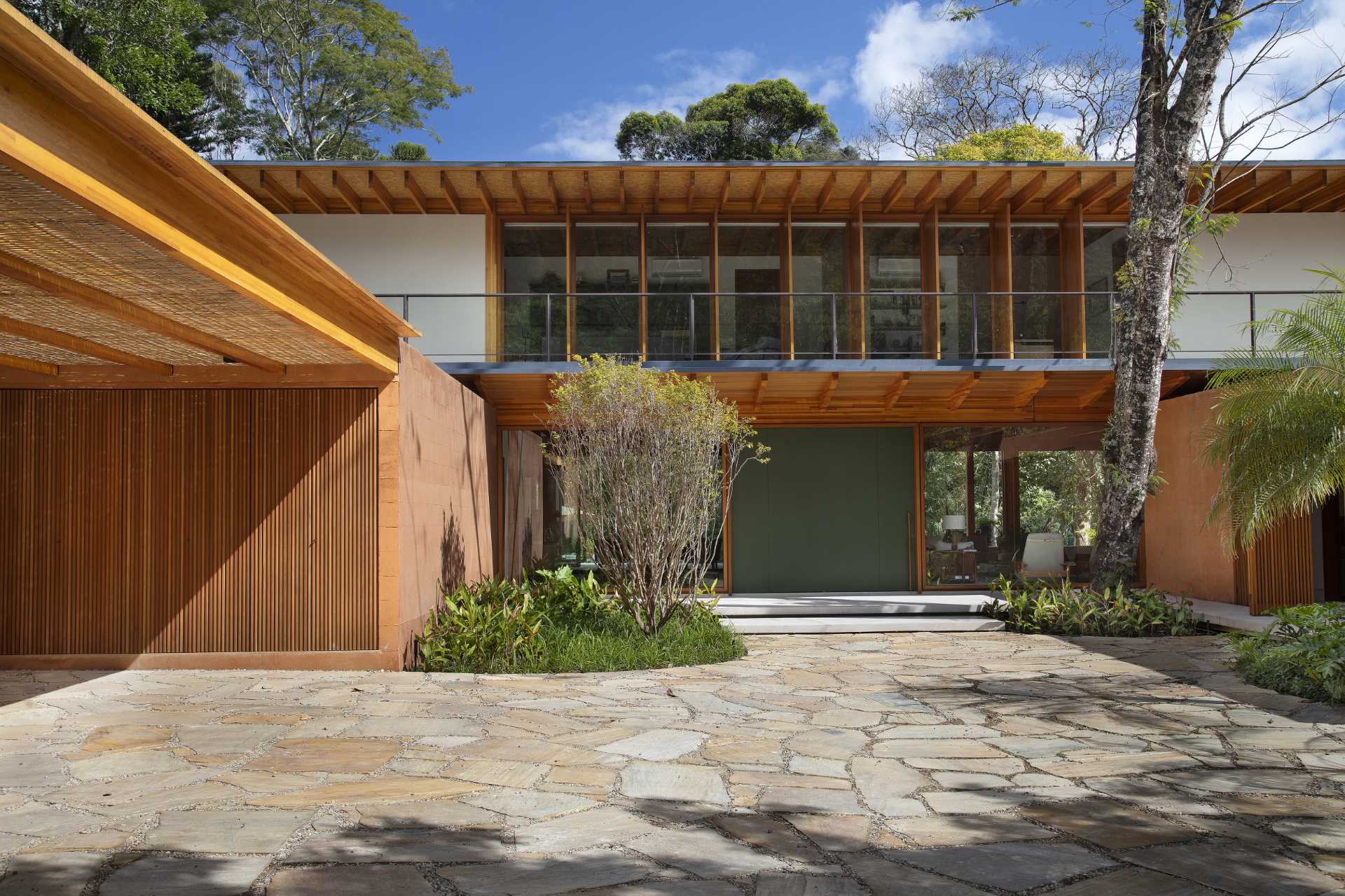 A modern house in Brazil has its post and beam structure on display throughout the interior and exterior.