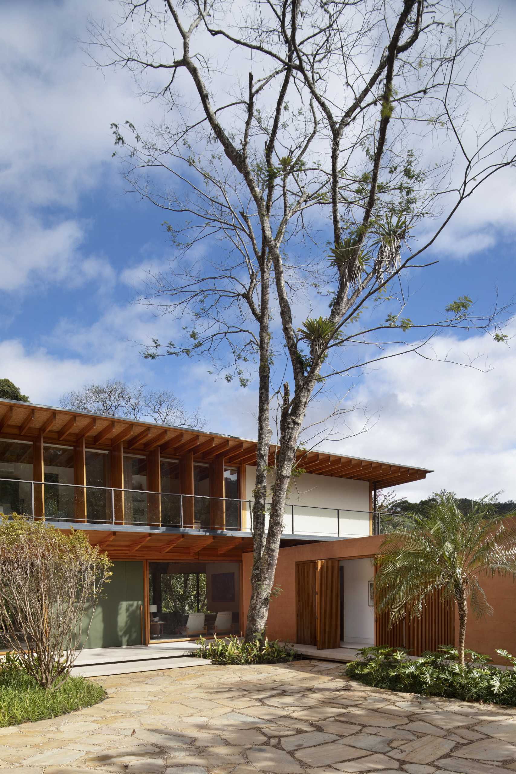 A modern house in Brazil has its post and beam structure on display throughout the interior and exterior.