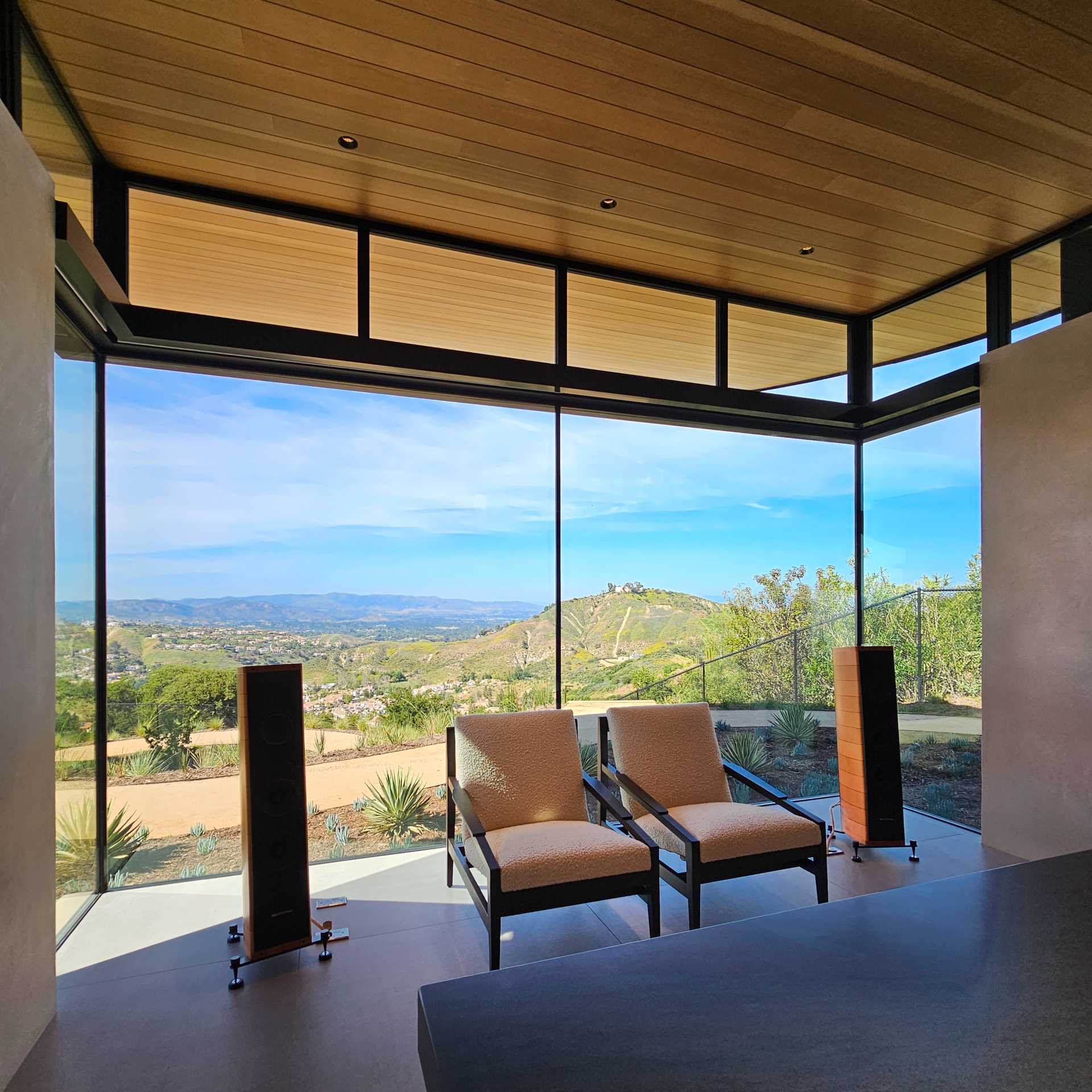 A modern home office with floor-to-ceiling windows provide natural light and expansive views.