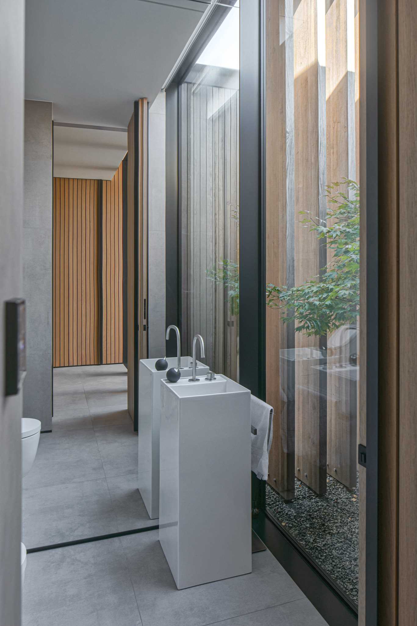 In this modern bathroom, a full wall mirror reflects the natural light throughout the space and makes the room feel larger than it is.