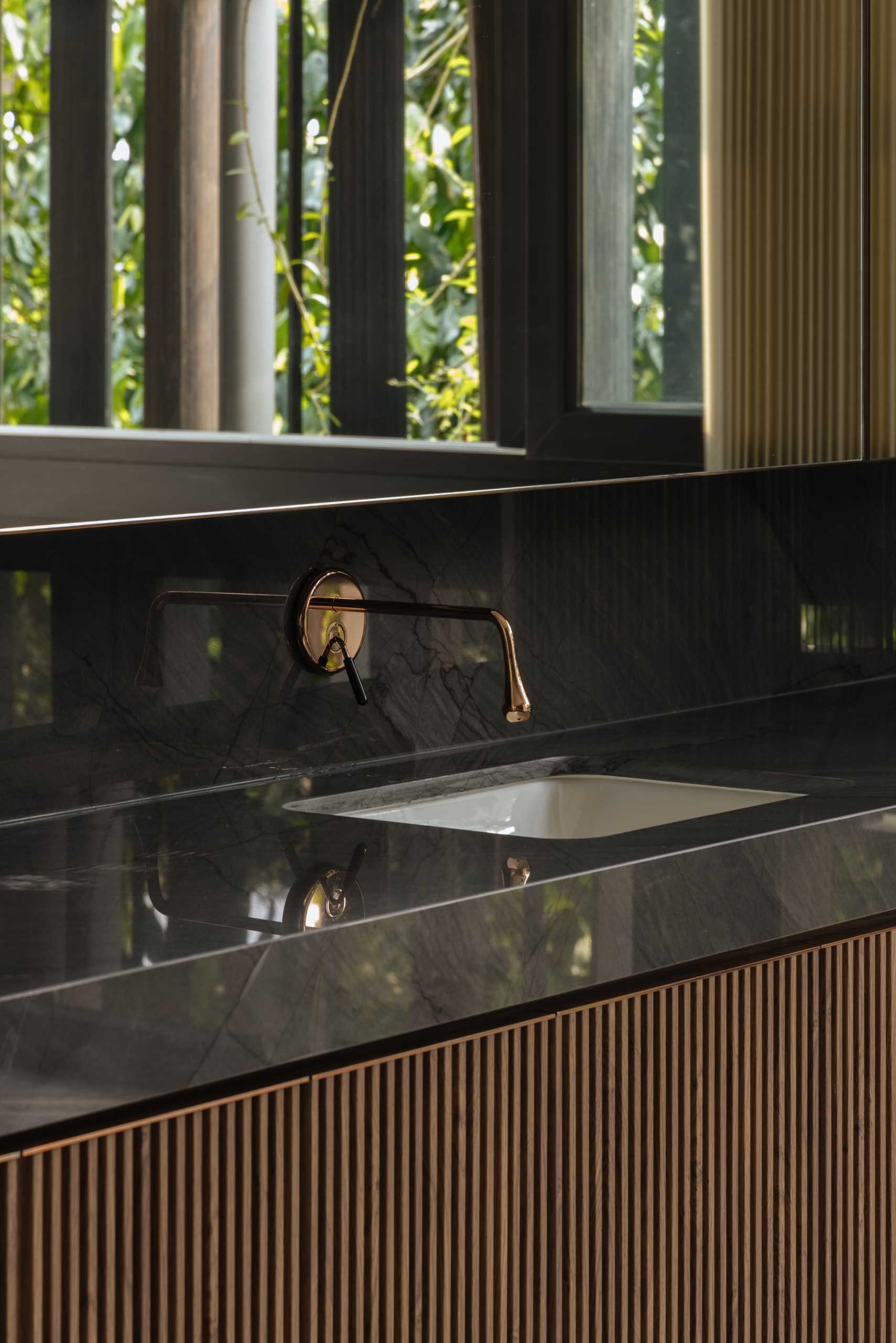 A modern bathroom with a black and wood vanity.